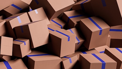 A large pile of brown cardboard boxes with blue tape.