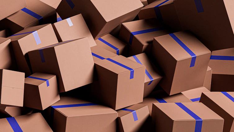 A large pile of brown cardboard boxes with blue tape.