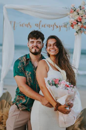 Couple posing on beach with flowers