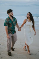 A couple walking hand-in-hand on a beach.