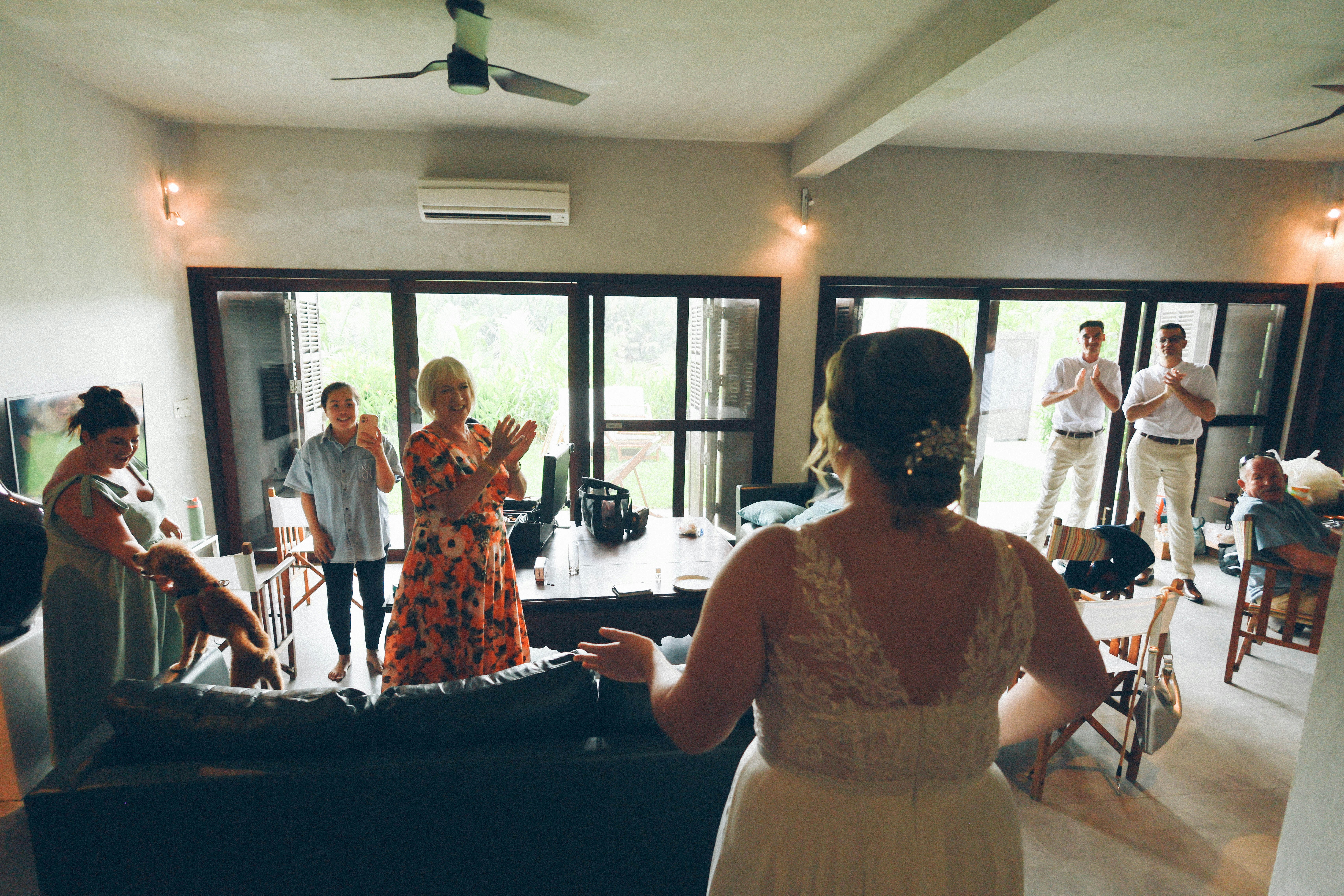 Bride enters room as guests clap and cheer
