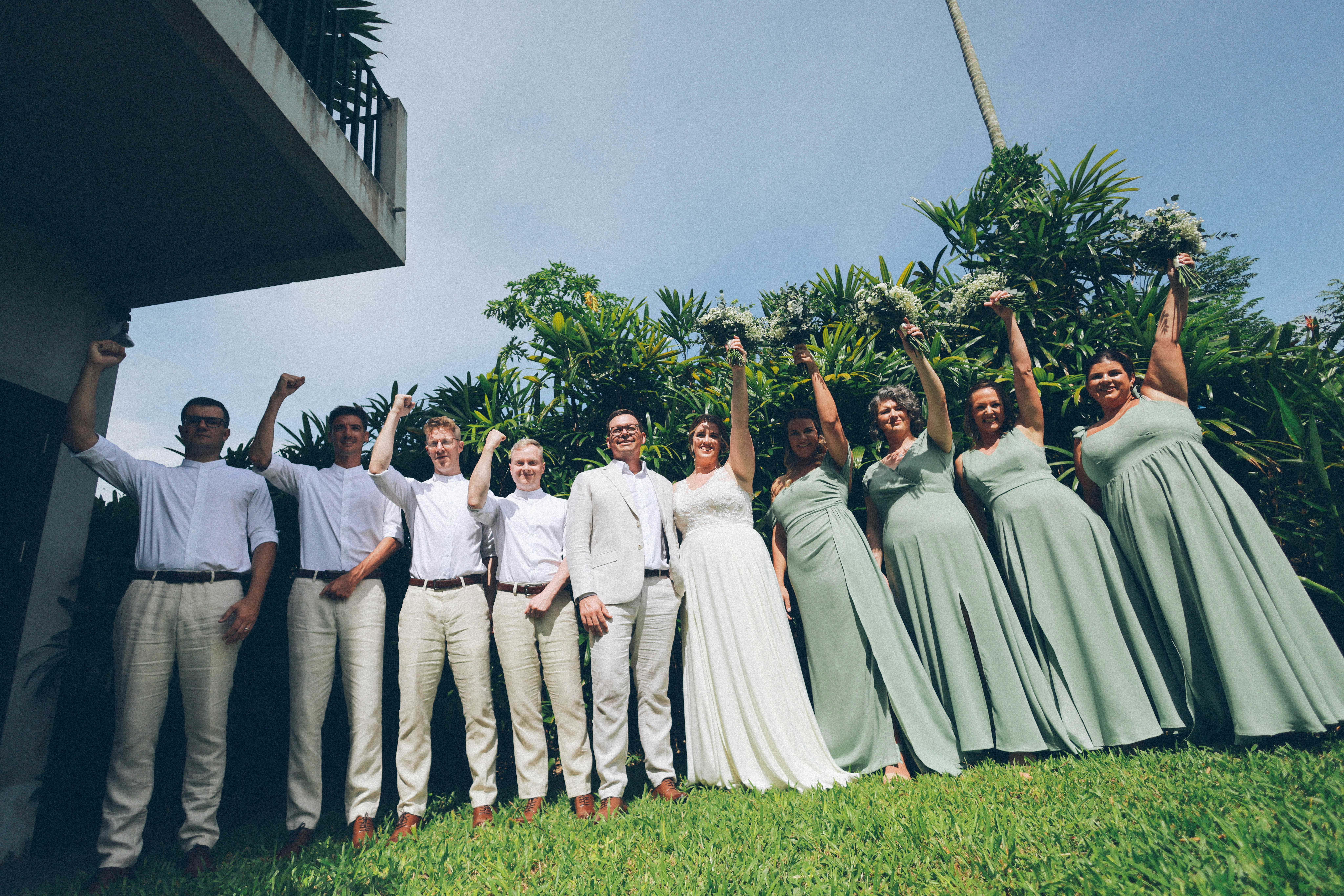 Wedding party raising fists with bouquets
