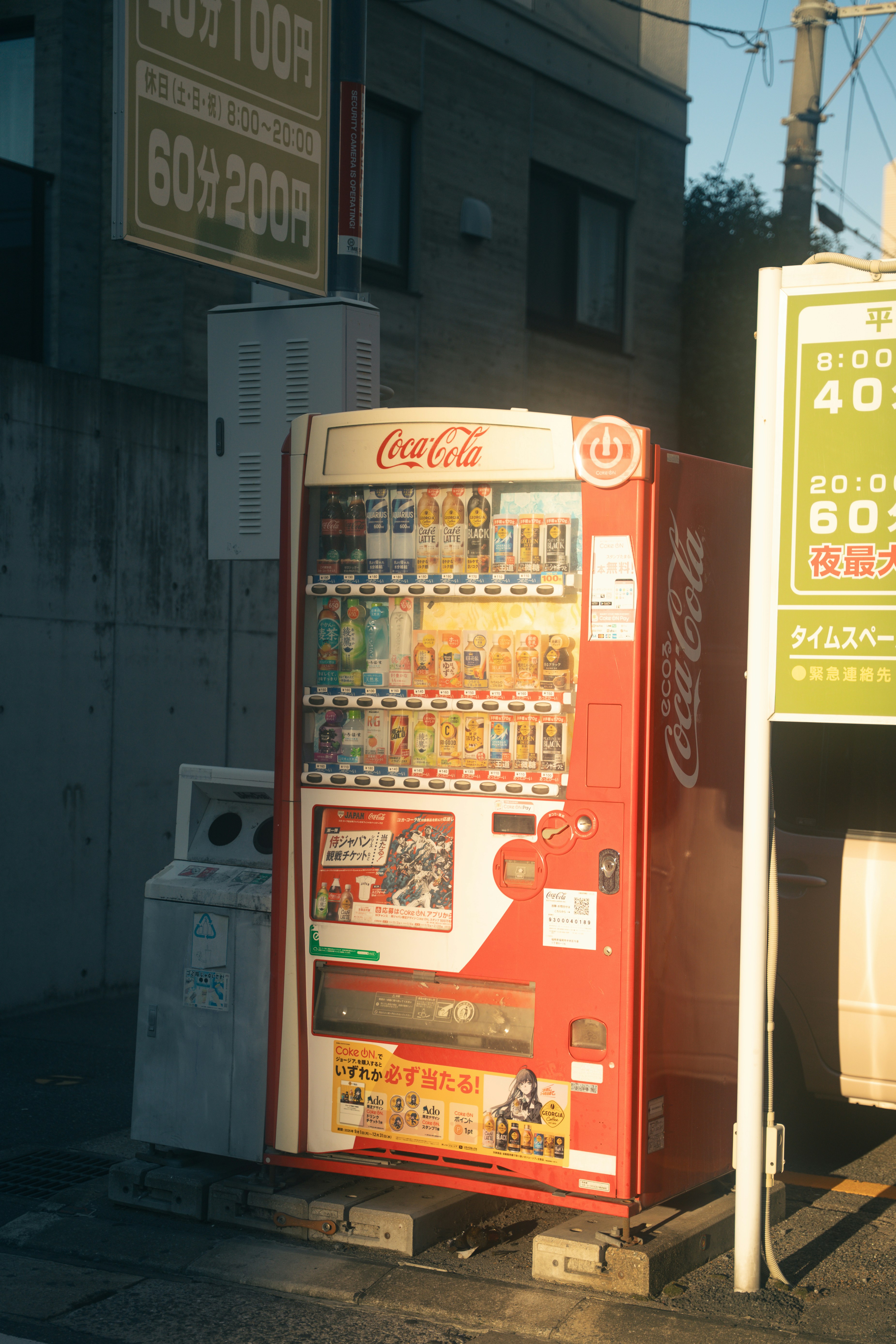 Distributeur de Coca-Cola rouge dans une rue.