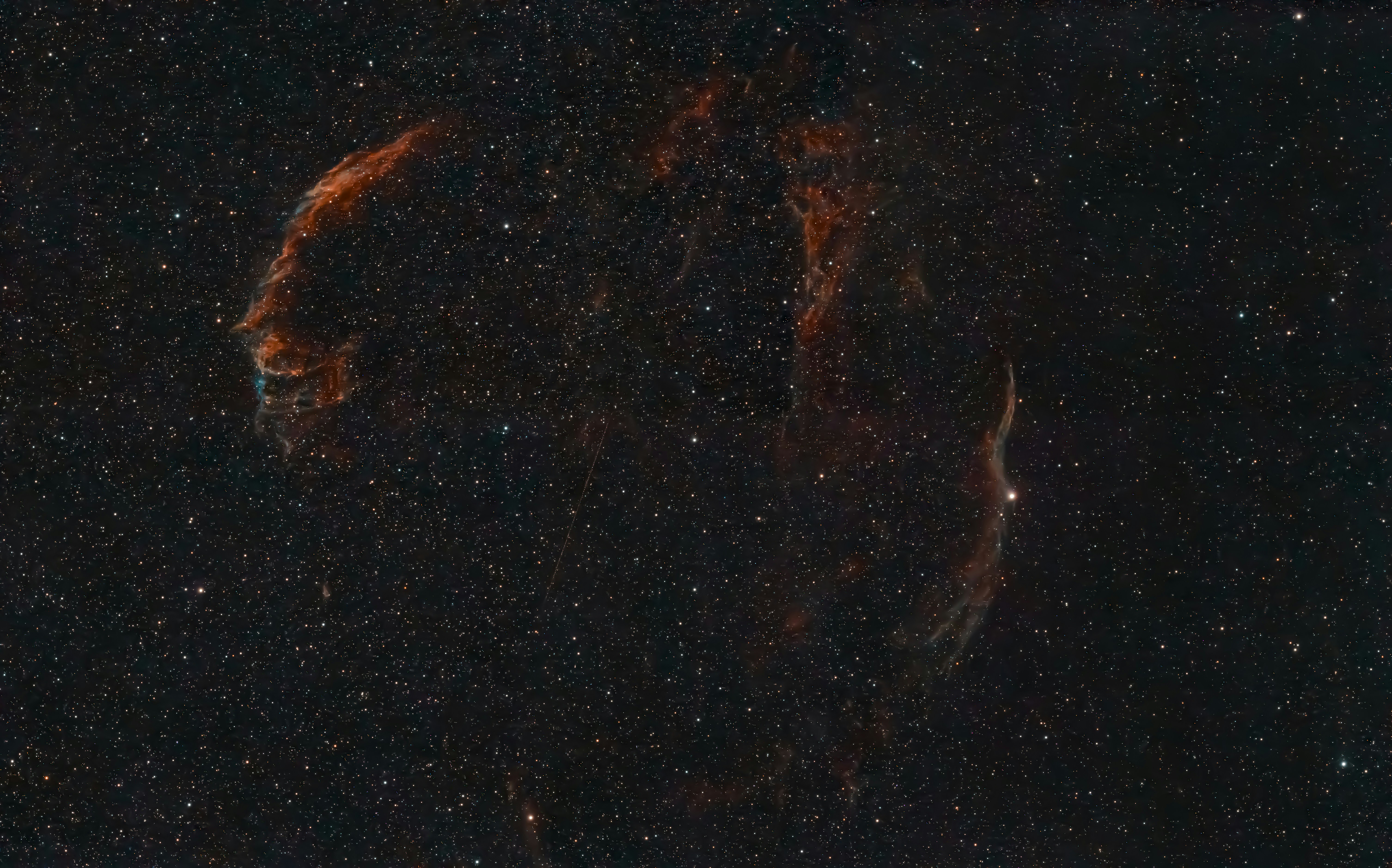 A faint nebula glows against a starry night sky.