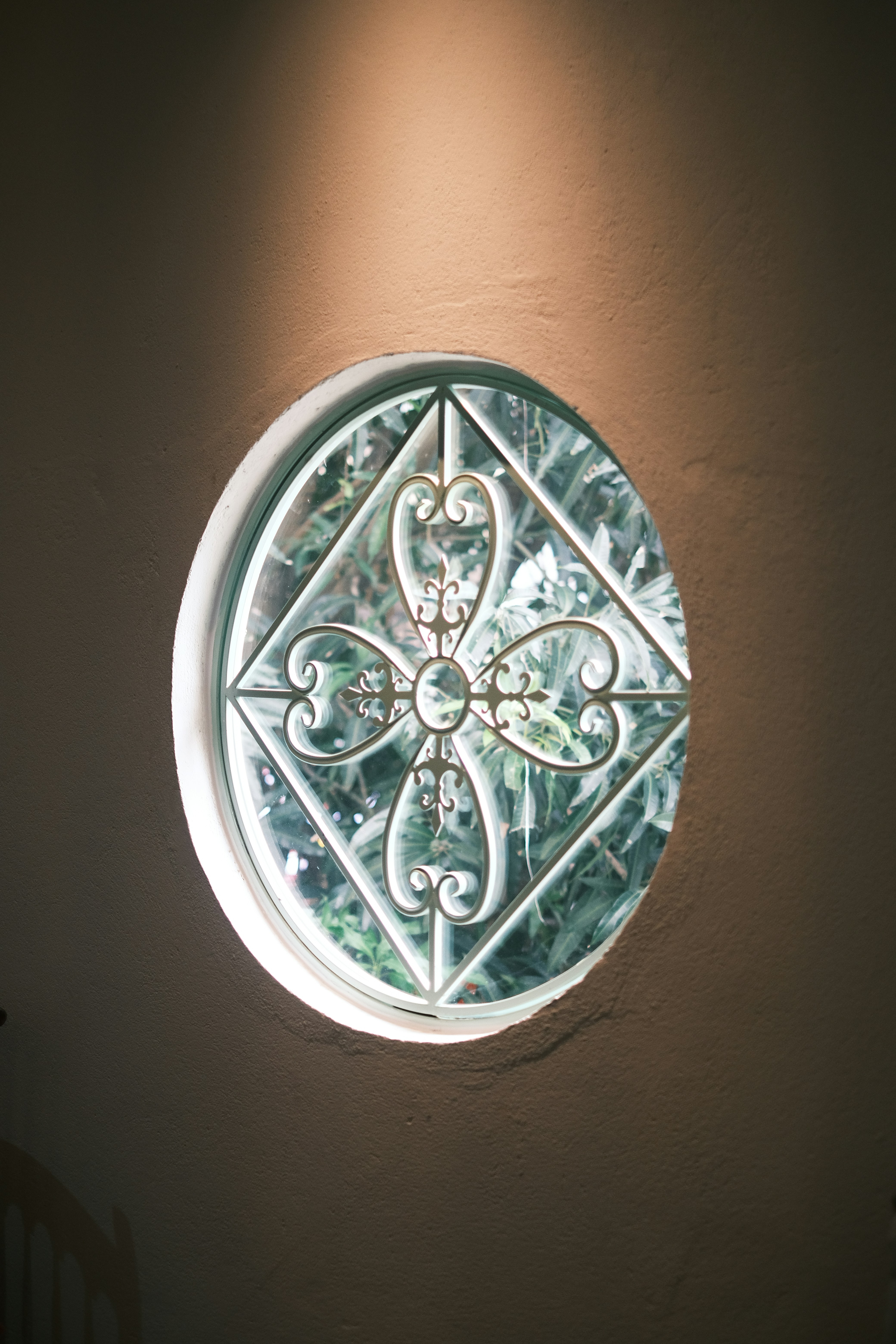 Round window with decorative glass and sunlight
