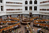 Grand library interior with many people reading