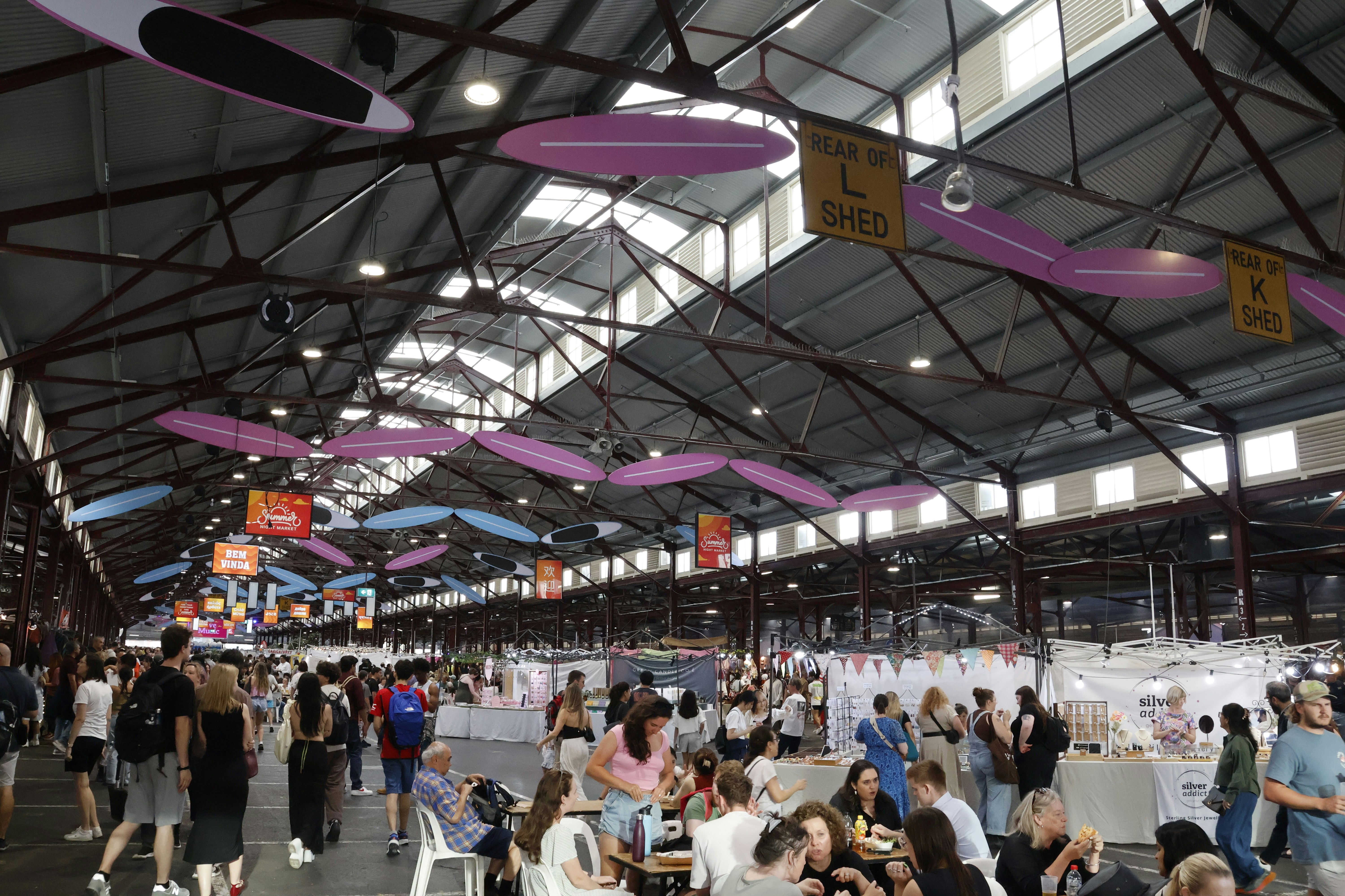 Busy indoor market with many shoppers and stalls.