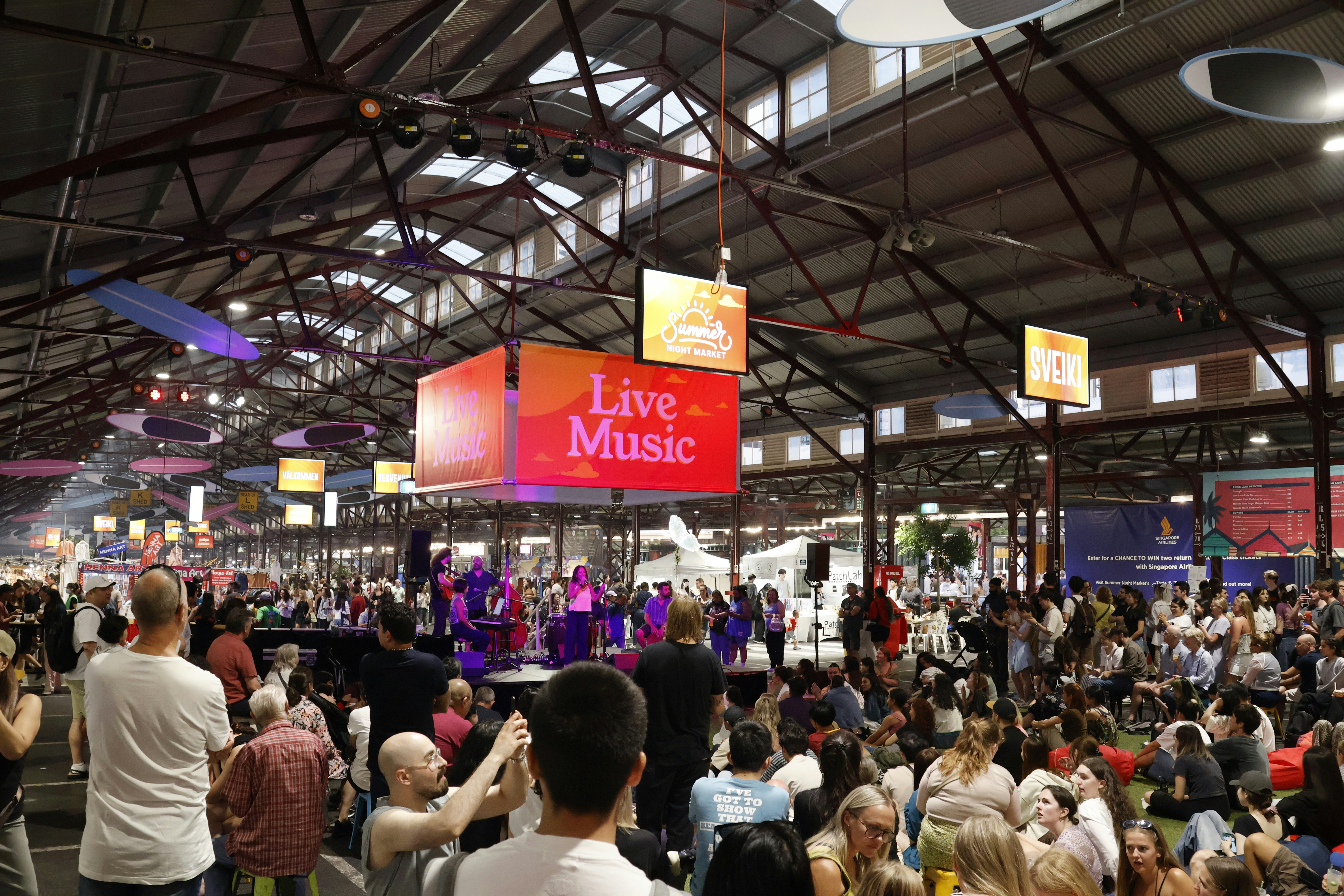 Crowd watches live music performance in large indoor venue