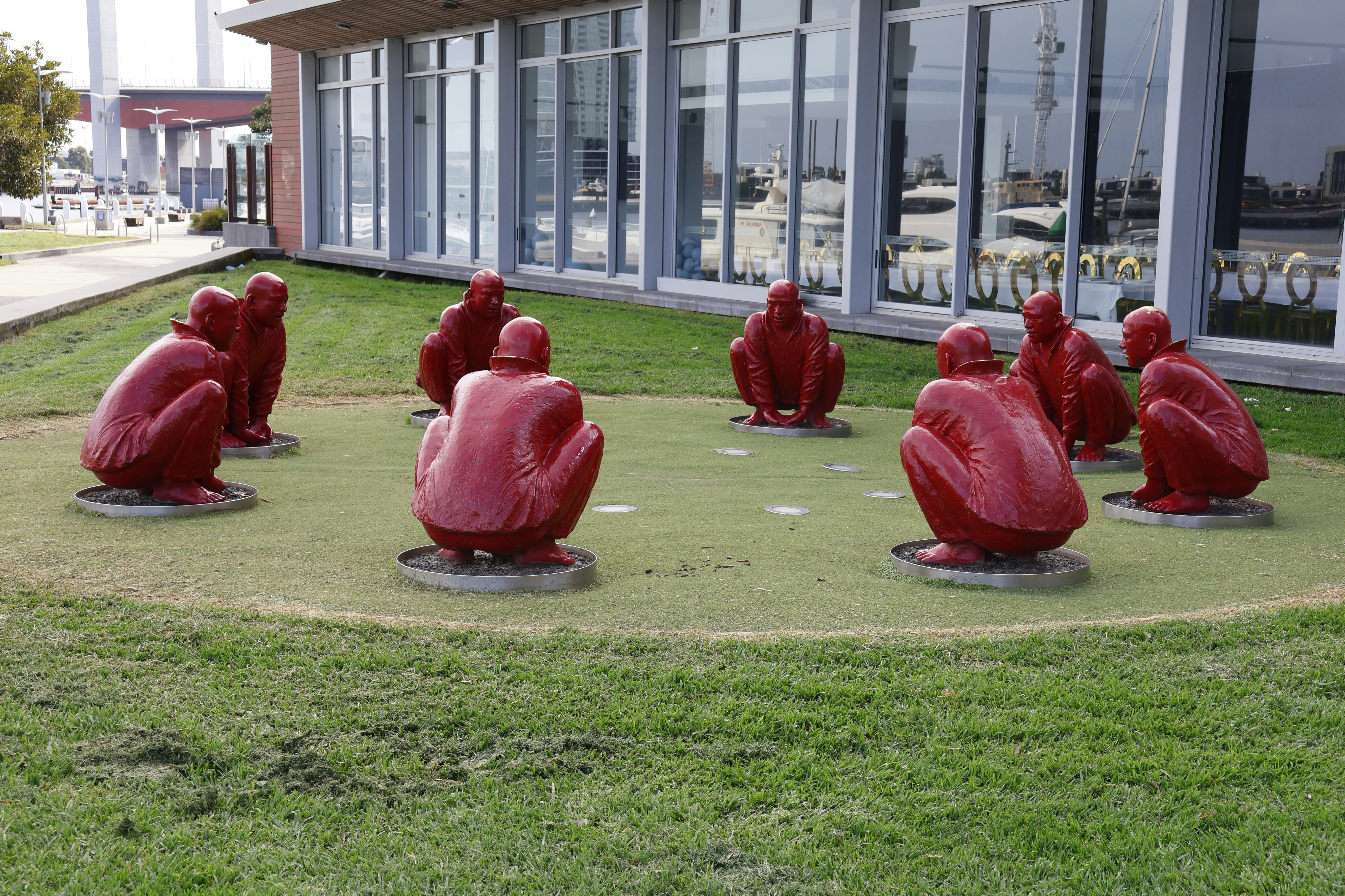 Red sculptures of people in a circle