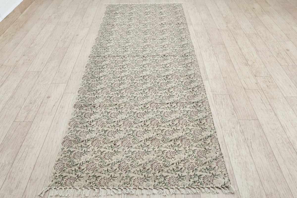 Low-pile runner rug on a wooden hallway floor - a non slip rug path for a senior dog