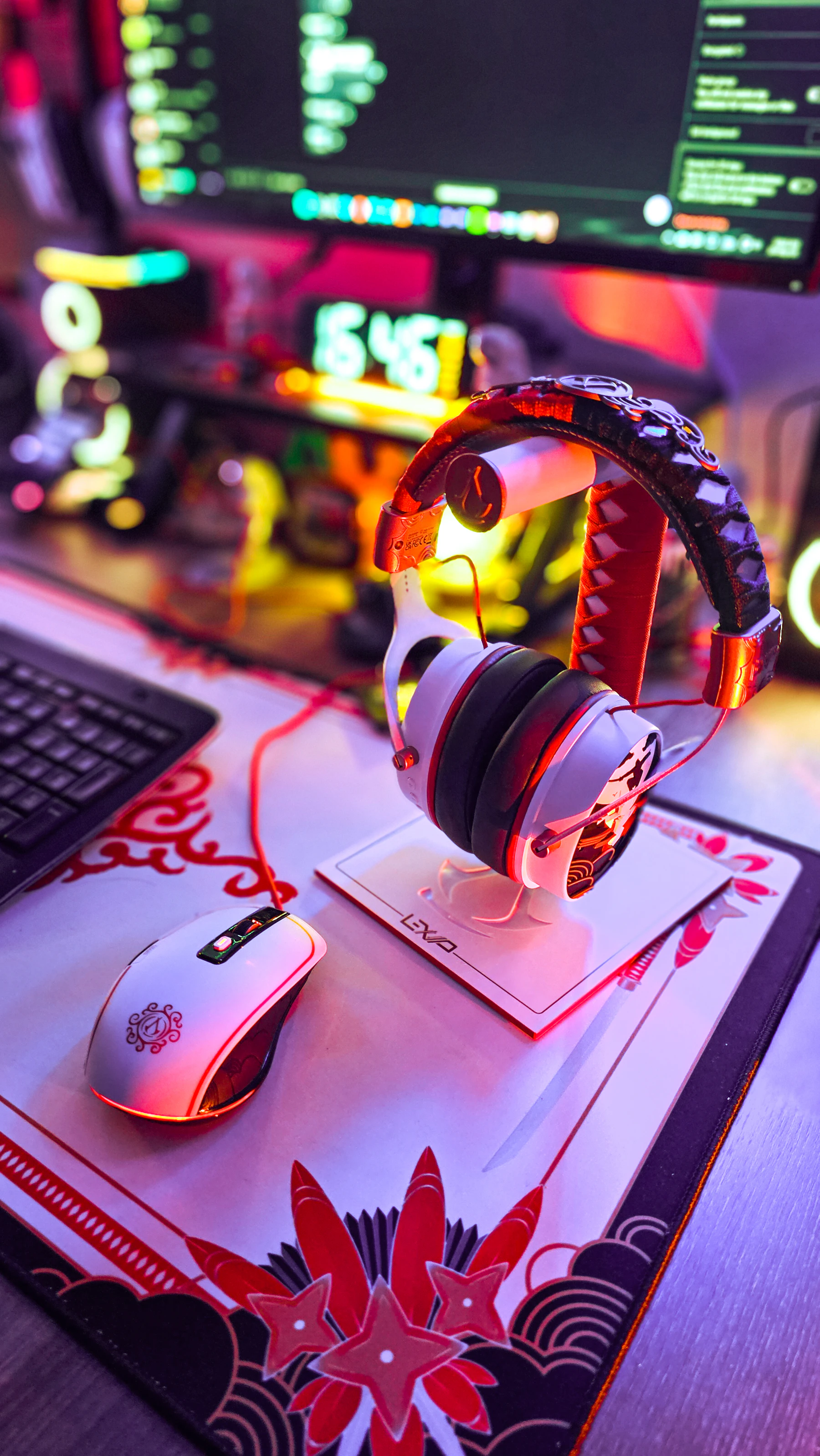 Gaming headset and gaming mouse arranged on a dark gaming desk