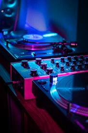 Dj turntables and mixer illuminated by neon lights