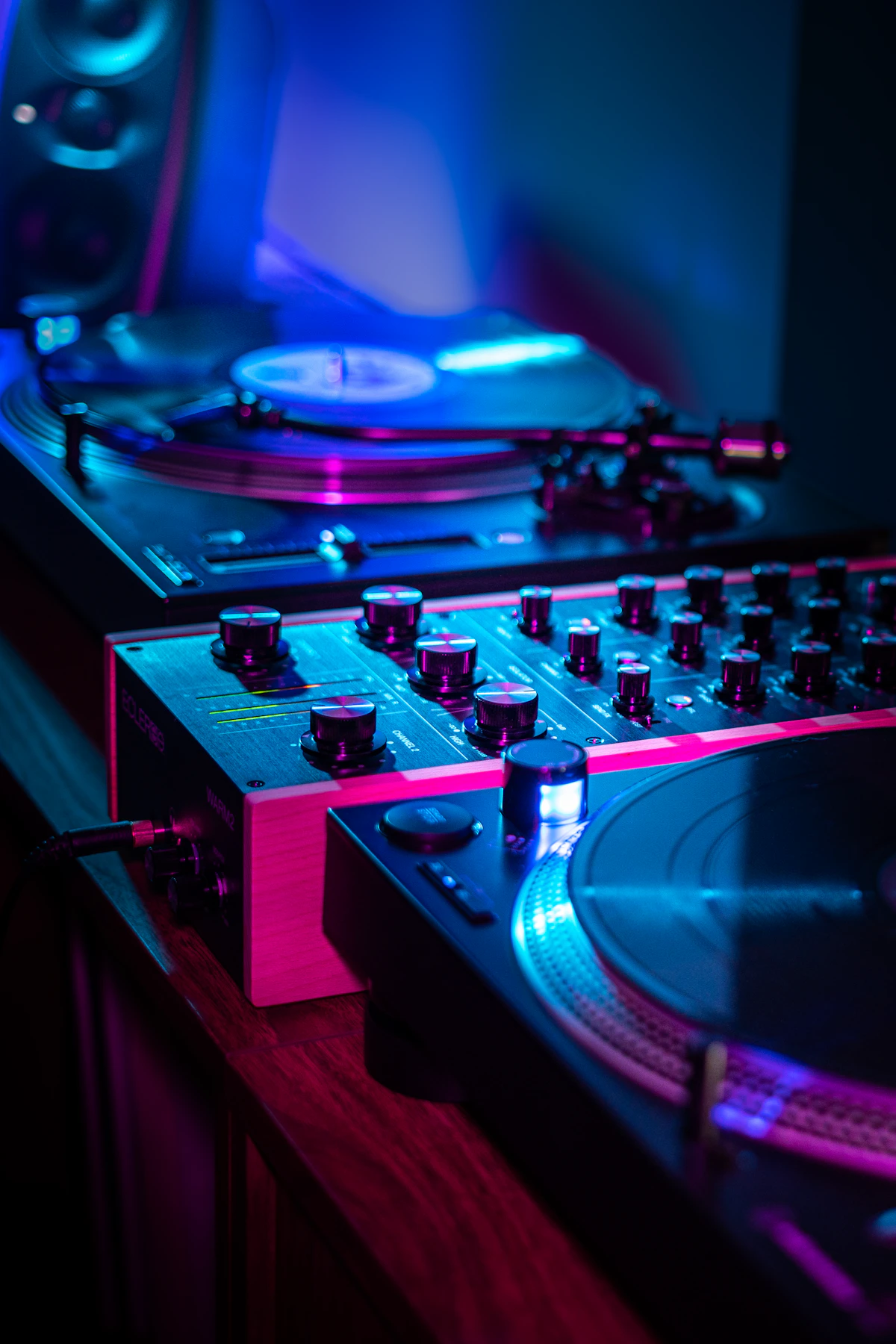 DJ turntables under blue and pink light