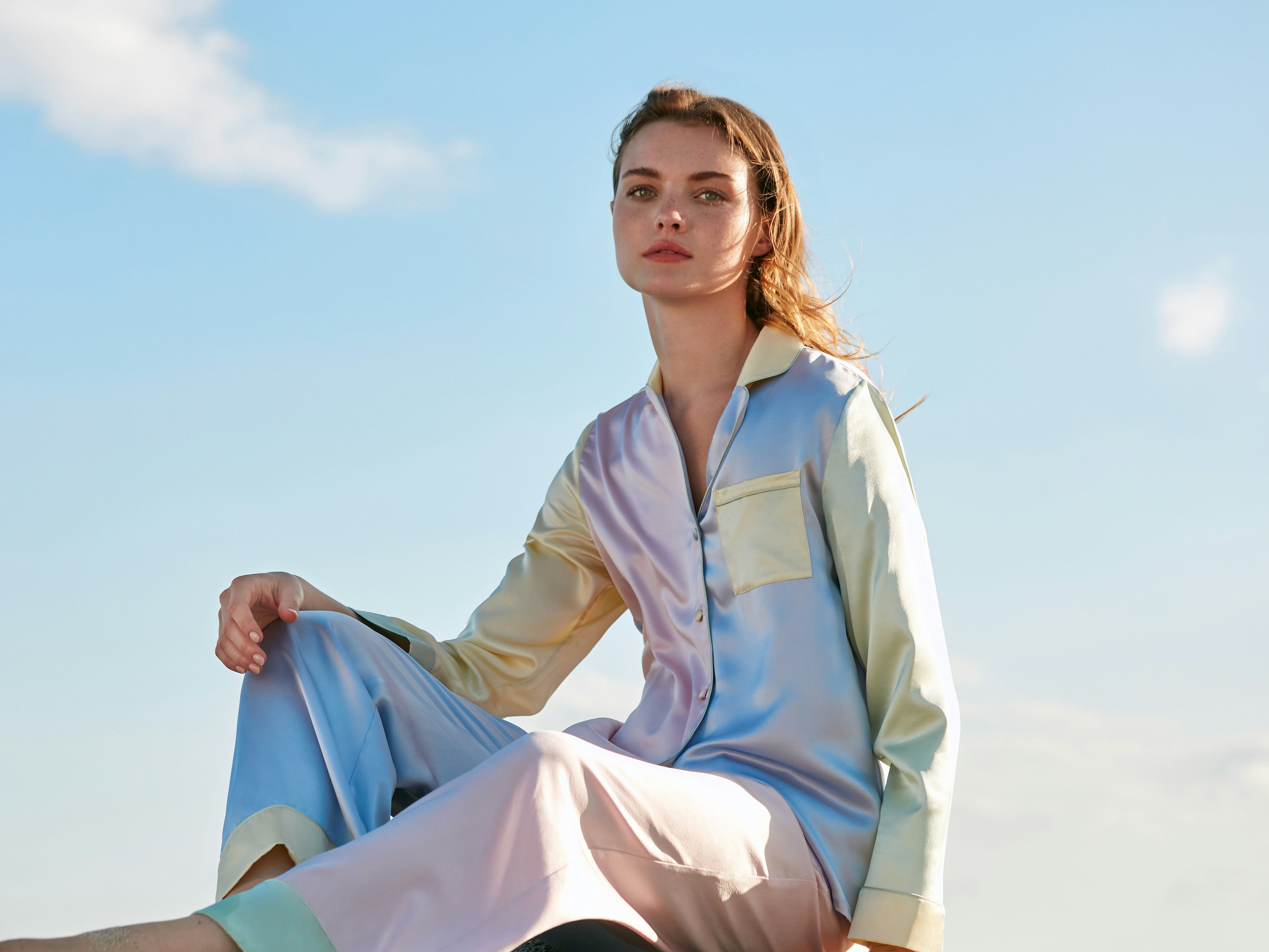 Woman in pastel pajamas against a blue sky