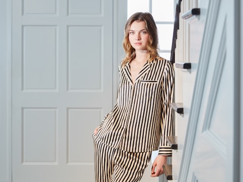 Young woman wearing striped pajamas indoors