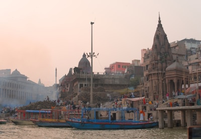 Boats on a river with ancient buildings and temples.