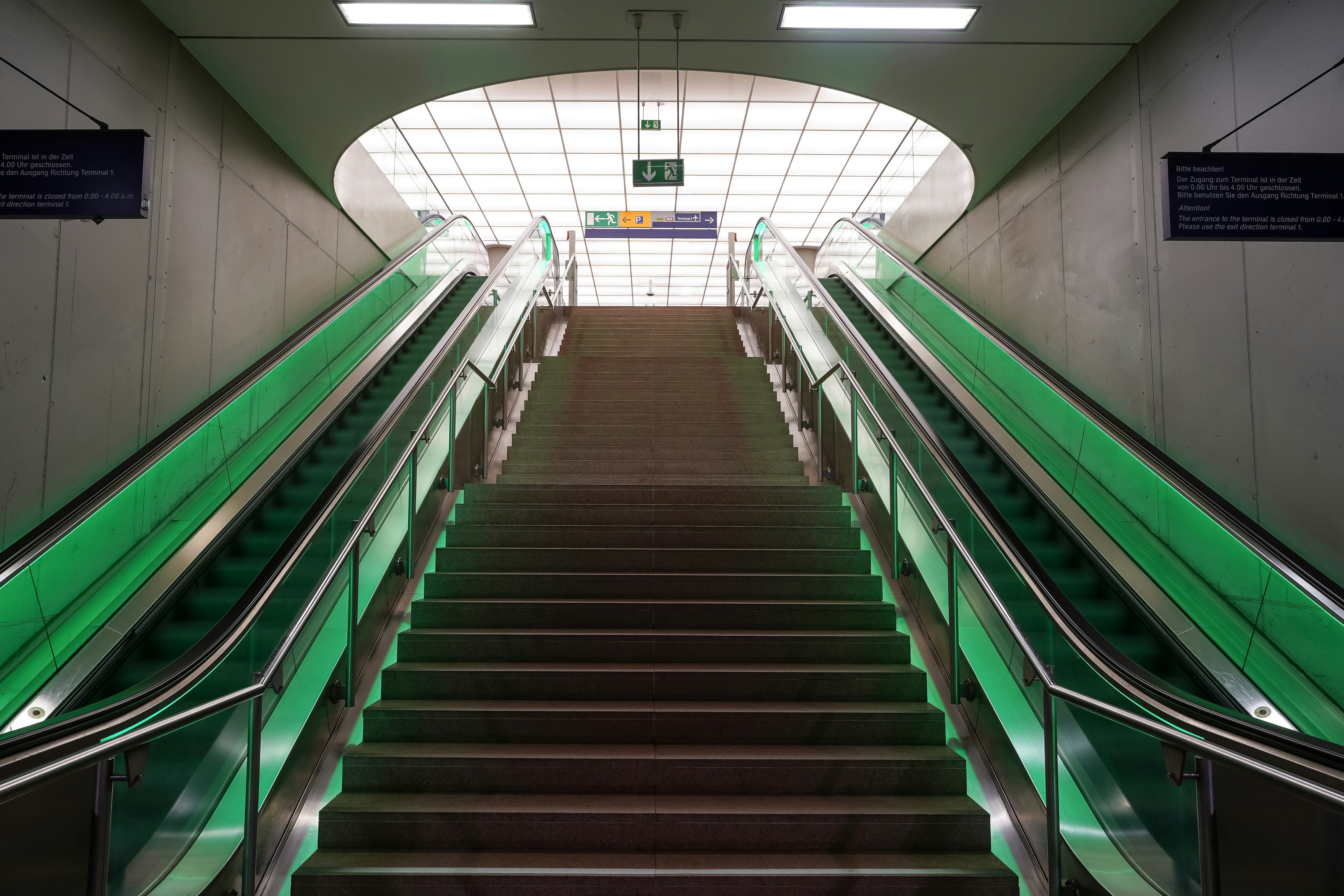 Modern escalator and stairs leading upwards in subway.