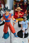 Goku and lionel messi action figures displayed together.