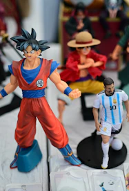 Goku and lionel messi action figures displayed together.