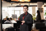 Man holding a laptop in a modern office setting.