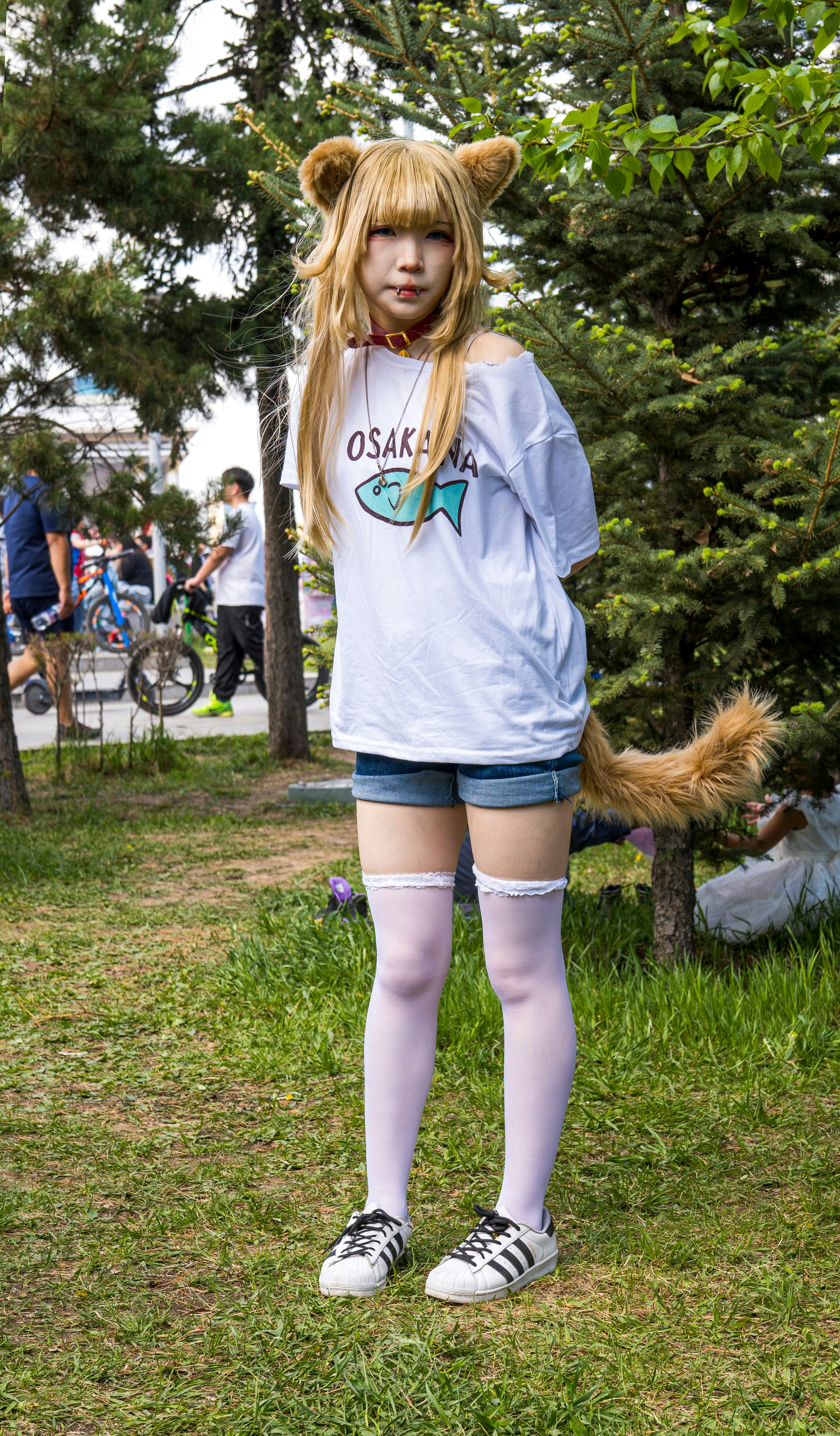Cosplayer with cat ears and tail in park