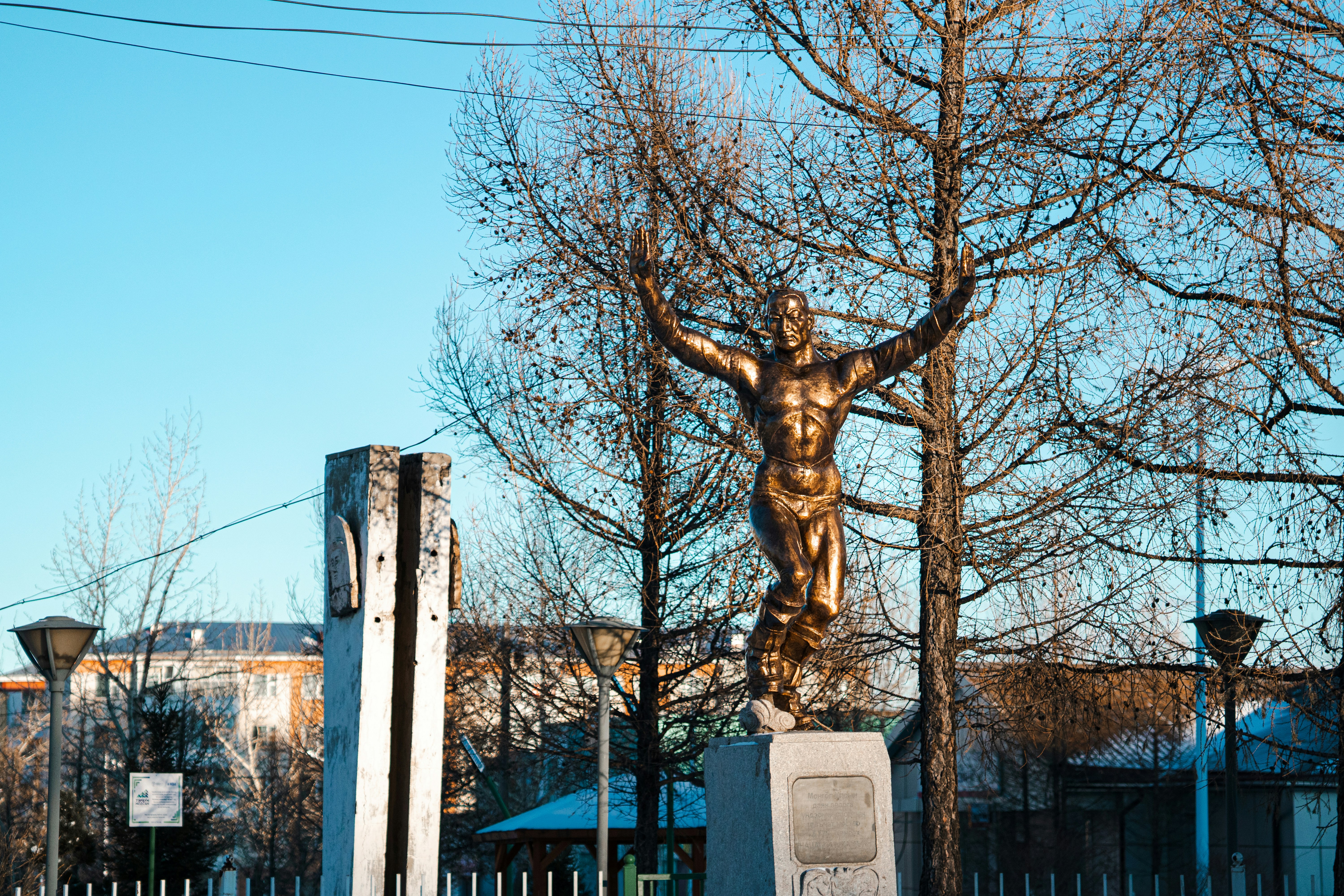 Golden statue of a man with arms raised