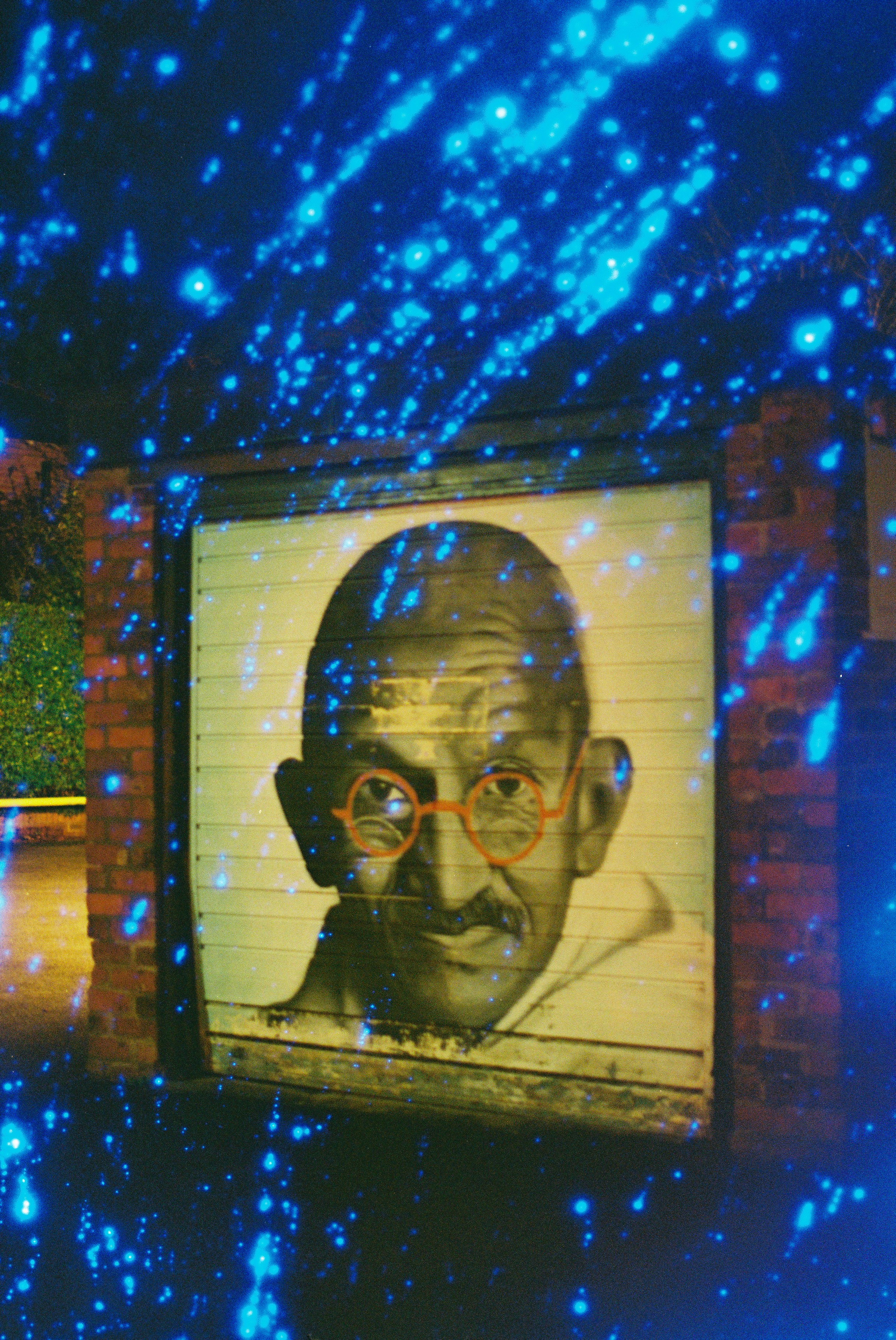 Mural Gandhi dengan garis-garis cahaya biru