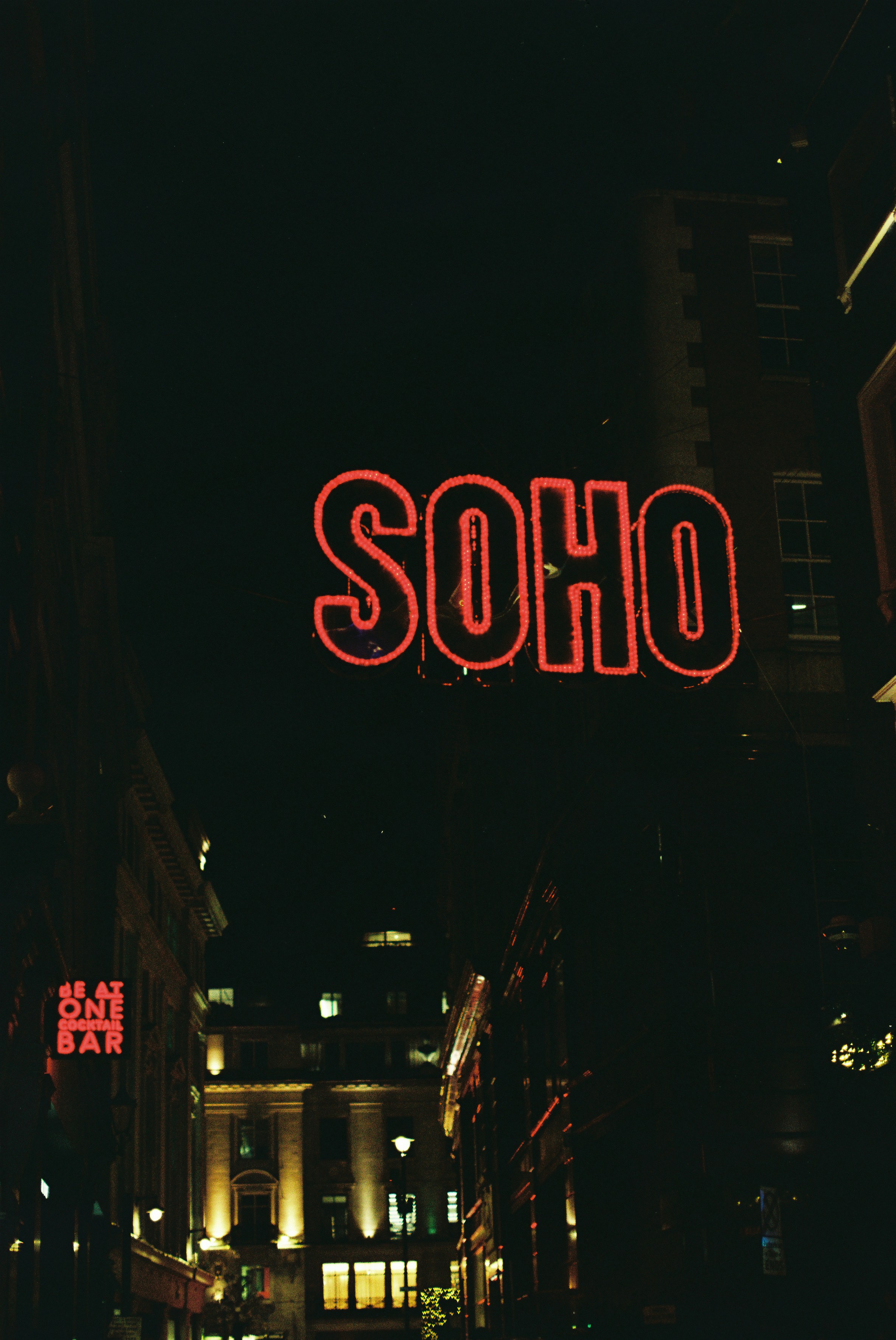 Neon soho sign illuminates dark city street at night. photo – Free Film ...