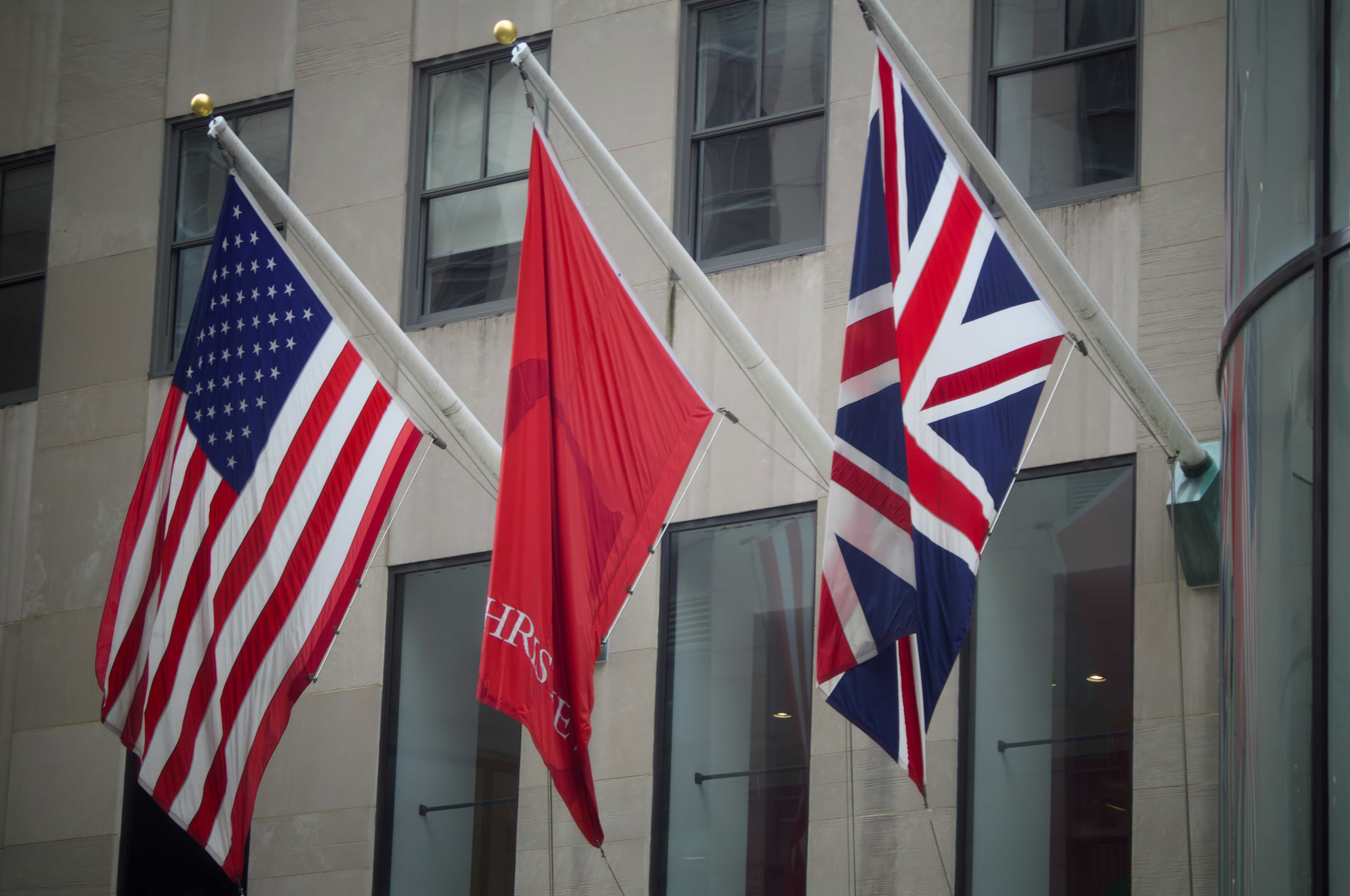 American, red, and union jack flags on building