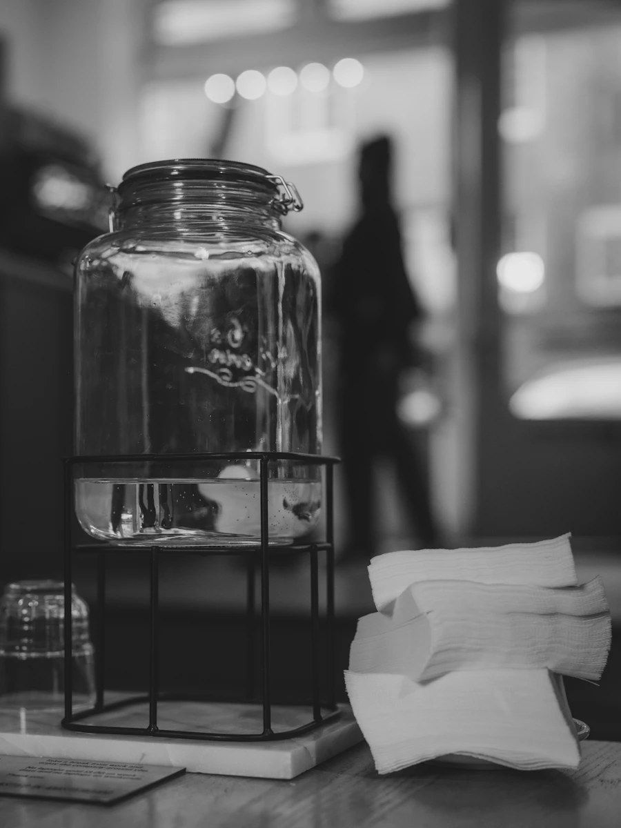 Glass water filtration carafe with napkins on a counter