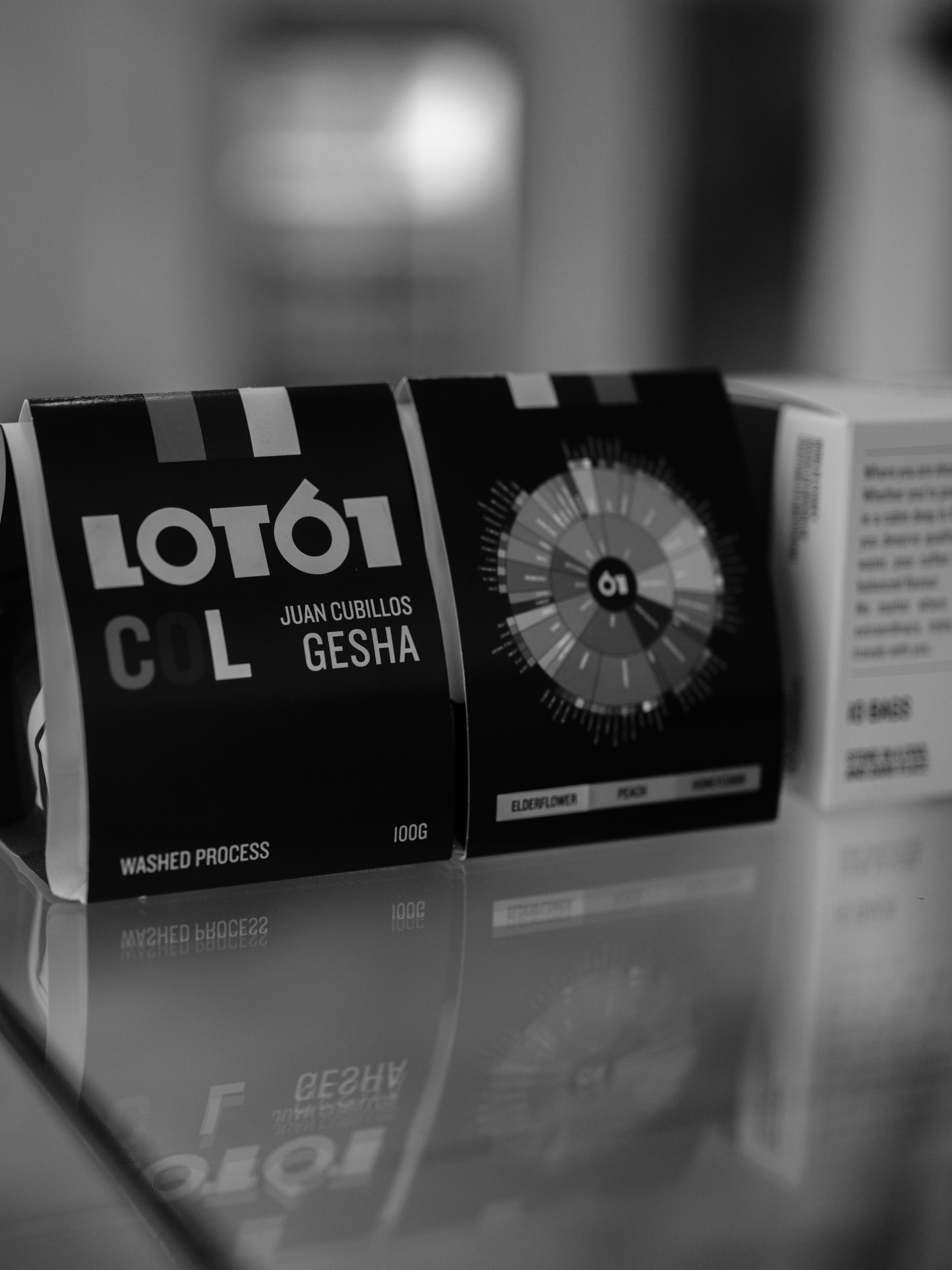 Three coffee bags on a reflective surface