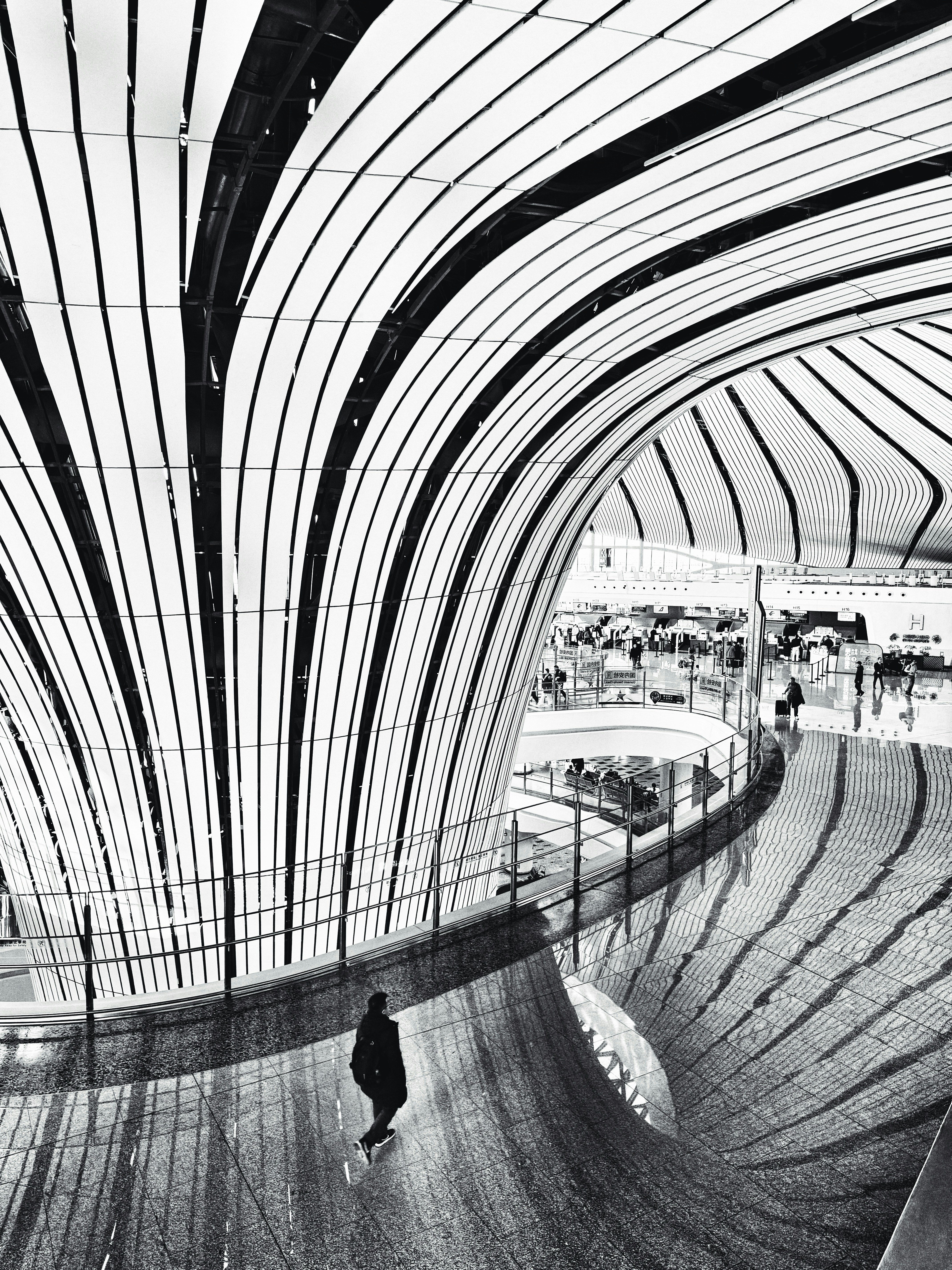 Modern architectural interior with curved lines and a person.