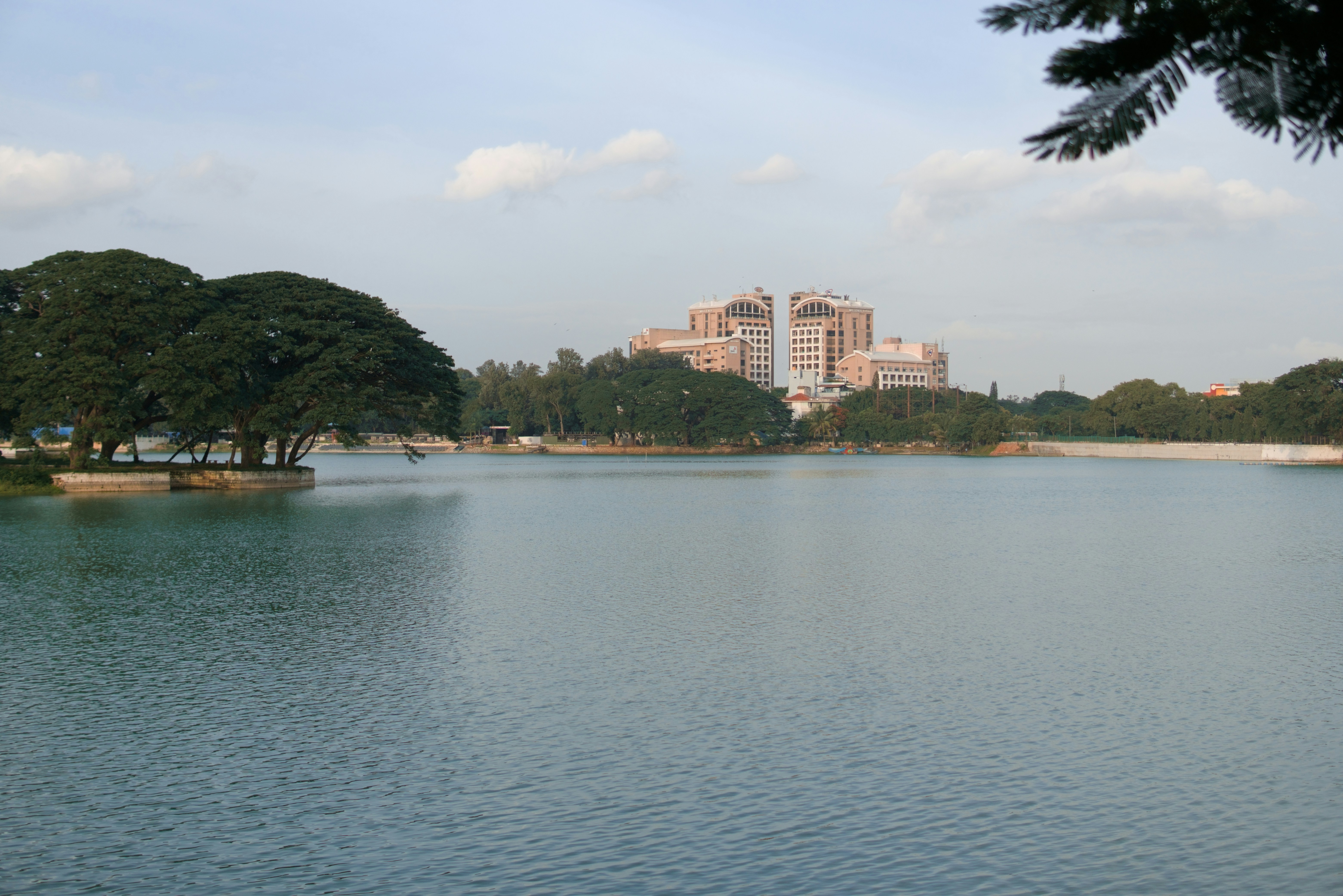 Calm lake with buildings and trees in background