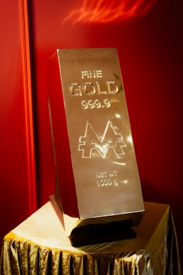 Large gold bar stamped 999.9 fine gold resting on a dark surface