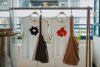 Two white t-shirts with floral appliques and bags