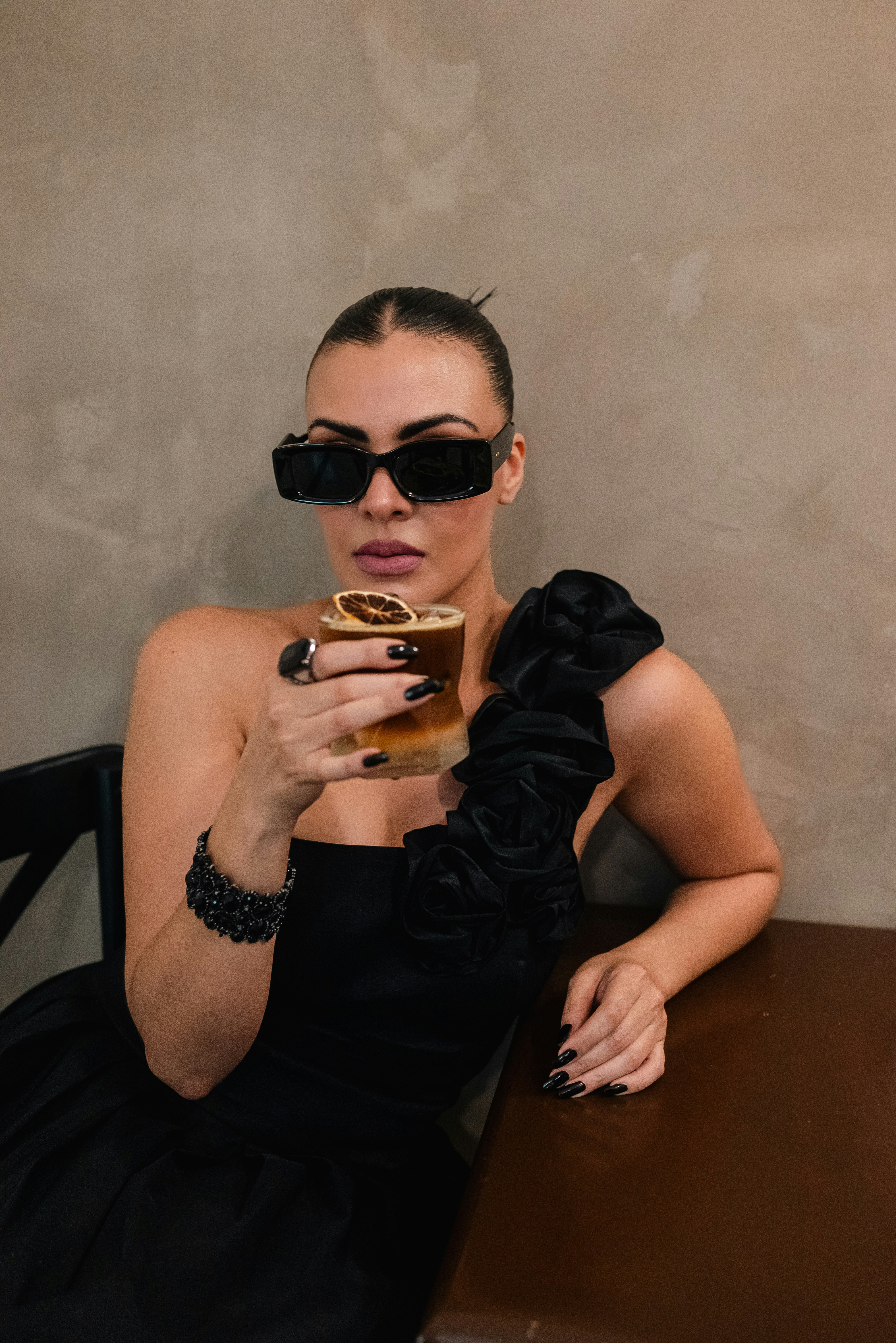 Woman in black dress holding a cocktail