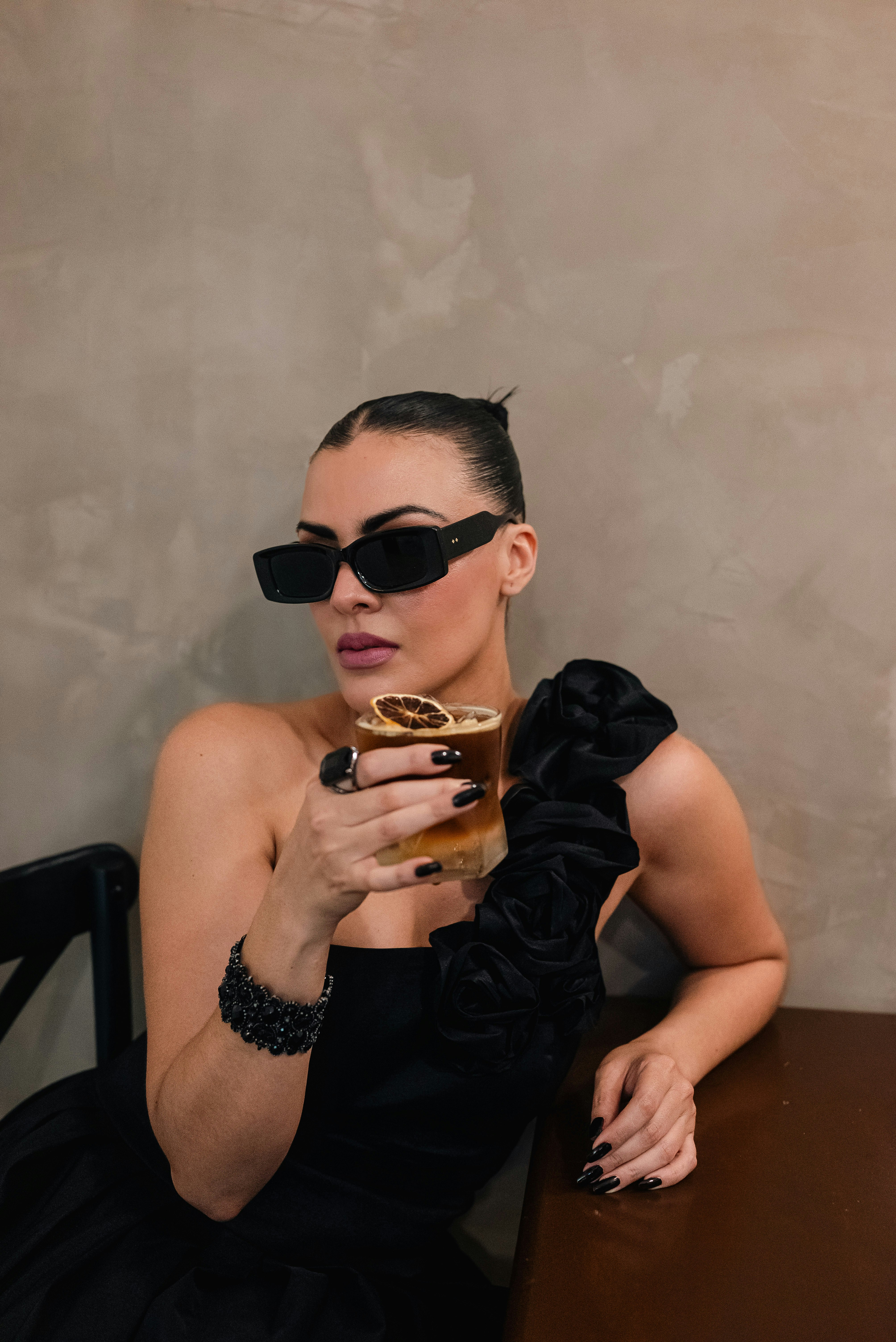 Woman in sunglasses holding a drink