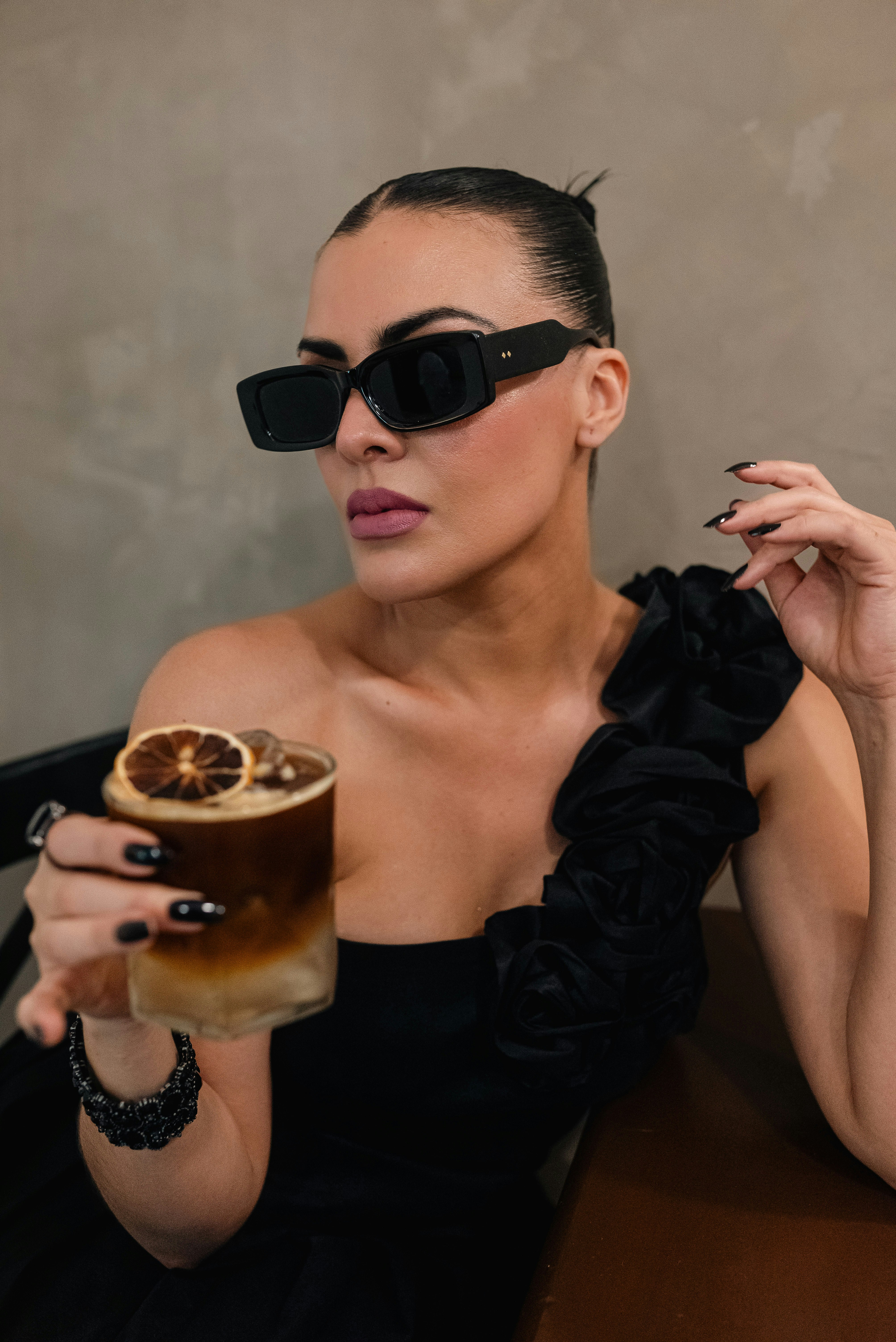 Woman in sunglasses holding a coffee drink