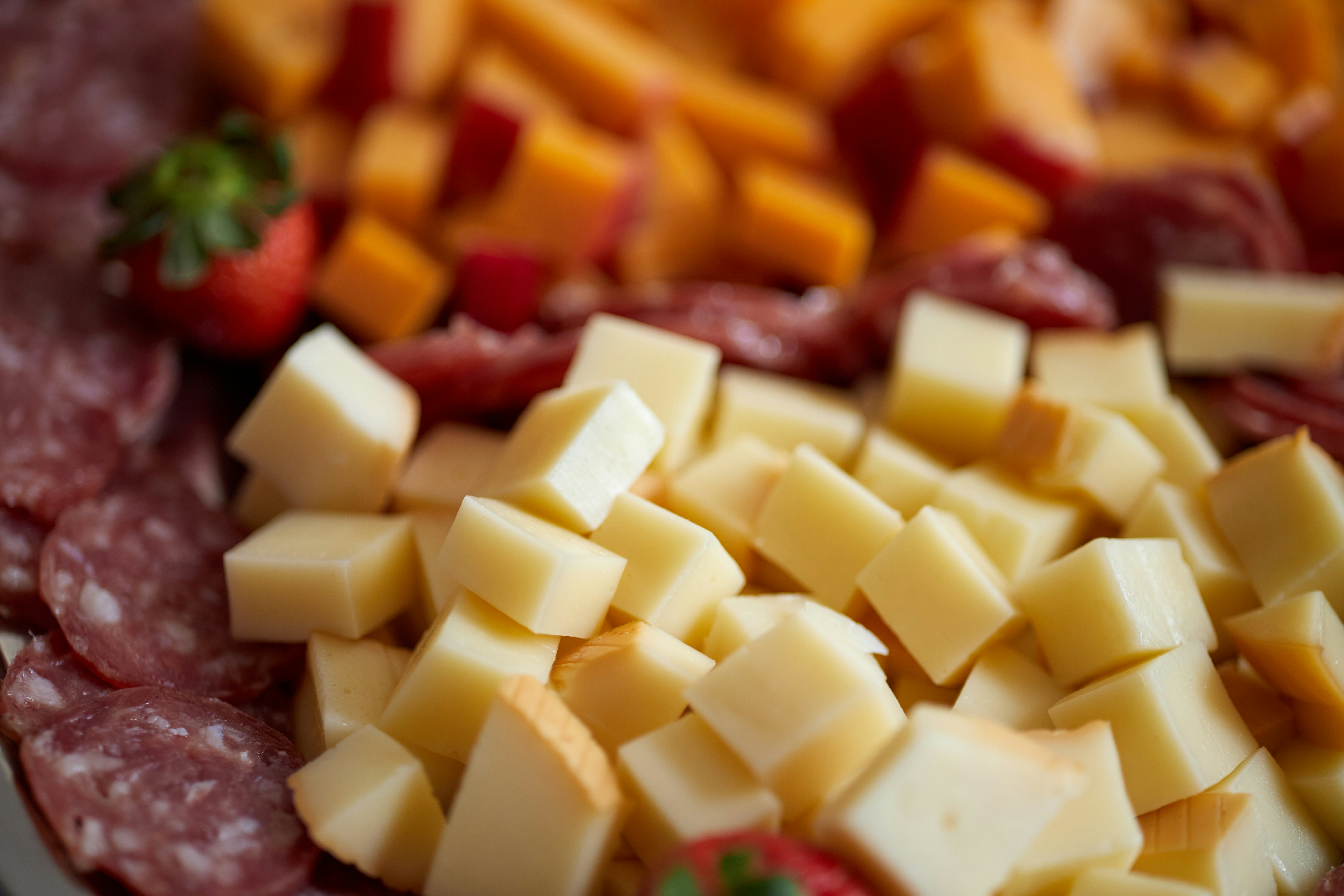 Gros plan sur le fromage en cubes, le salami et les fraises.