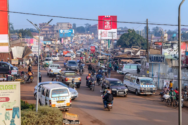 Busy street with cars, motorcycles, and buildings.