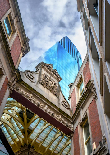 Modern blue skyscraper seen through ornate archway