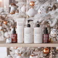 Skincare products arranged on a shelf with christmas decorations.