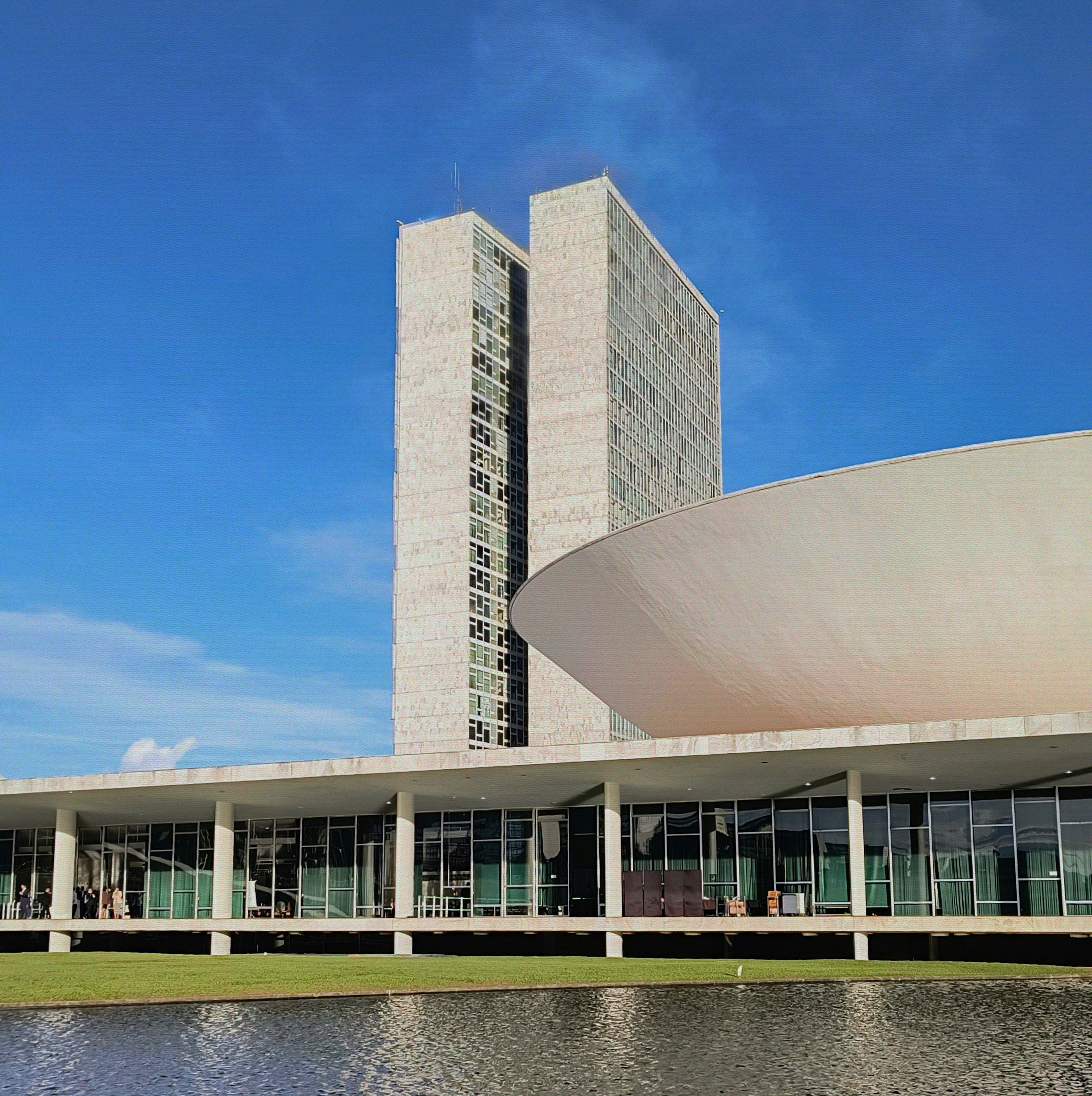 Modern building with curved roof and tall tower.