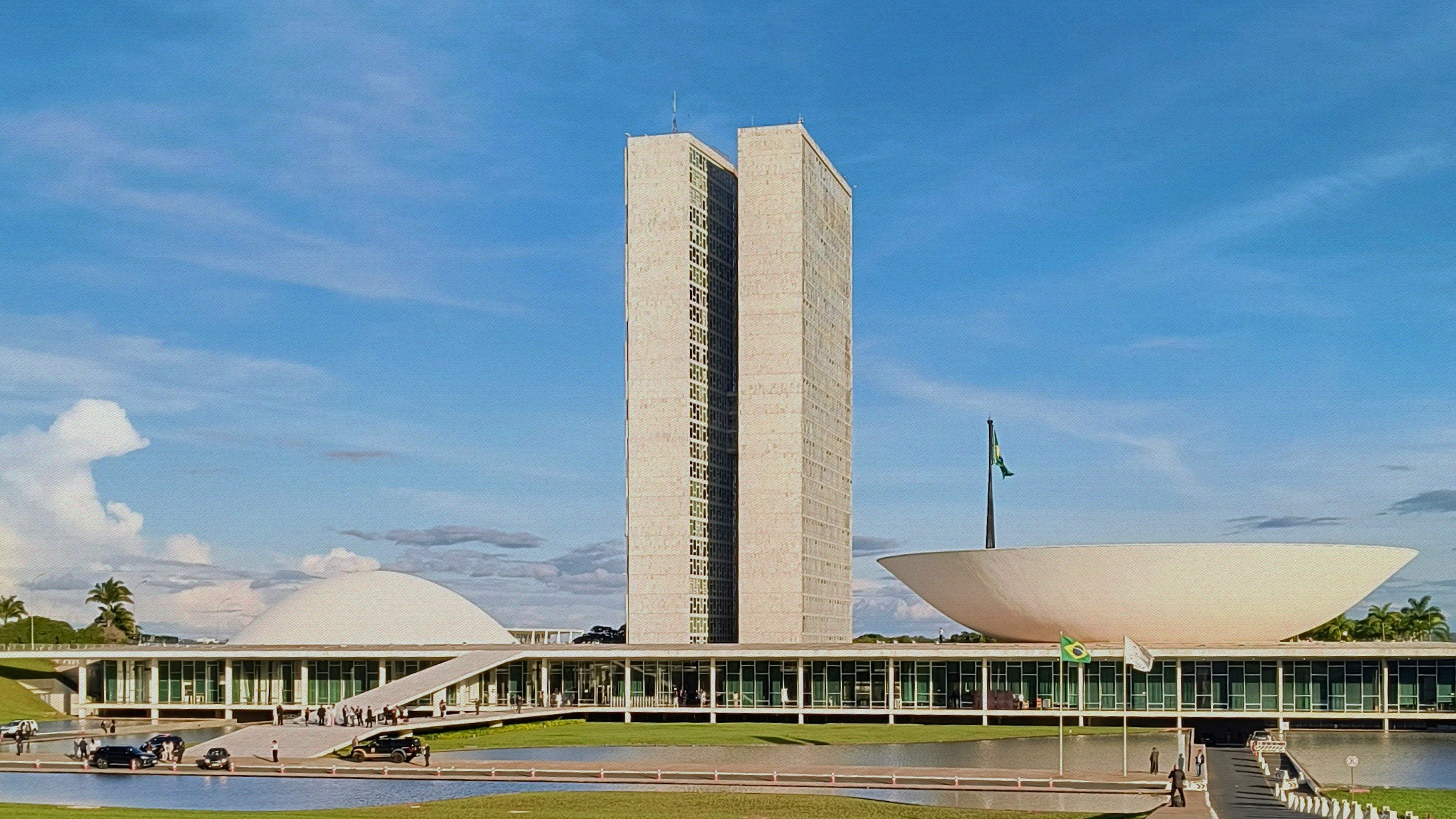 Modern building with dome and tall tower under sky.