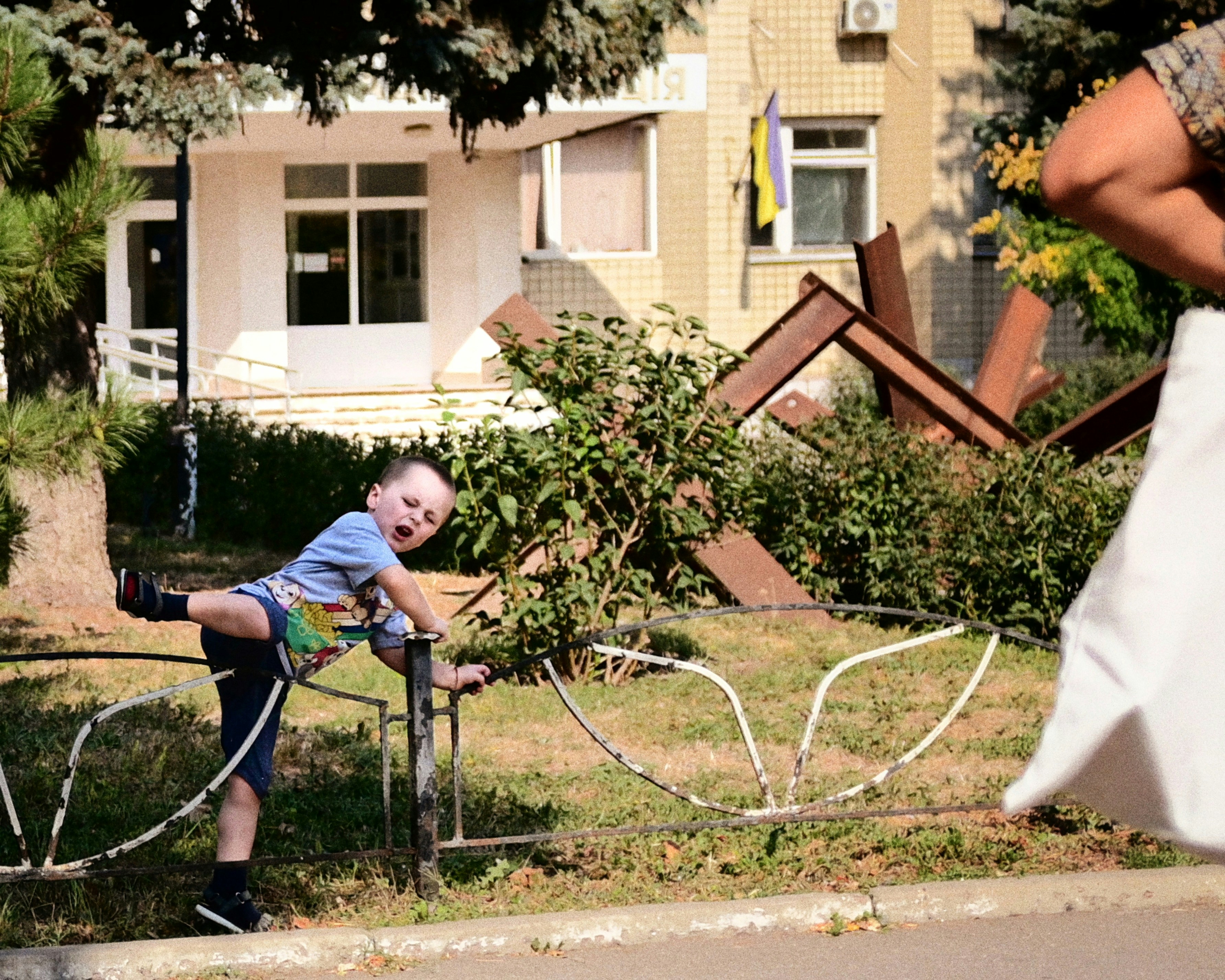 A young boy plays near a military obstacle.