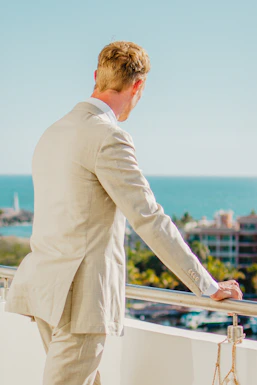 Man in a suit looking out at the ocean