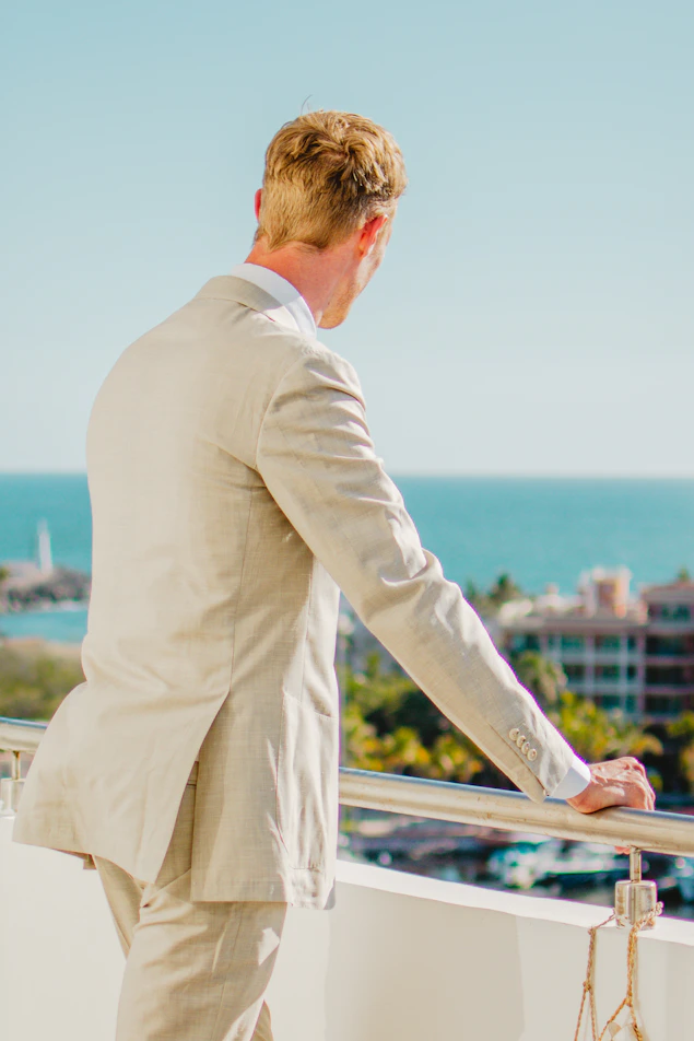 Man in a suit looking out at the ocean
