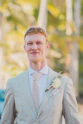A smiling man in a light-colored suit and tie.