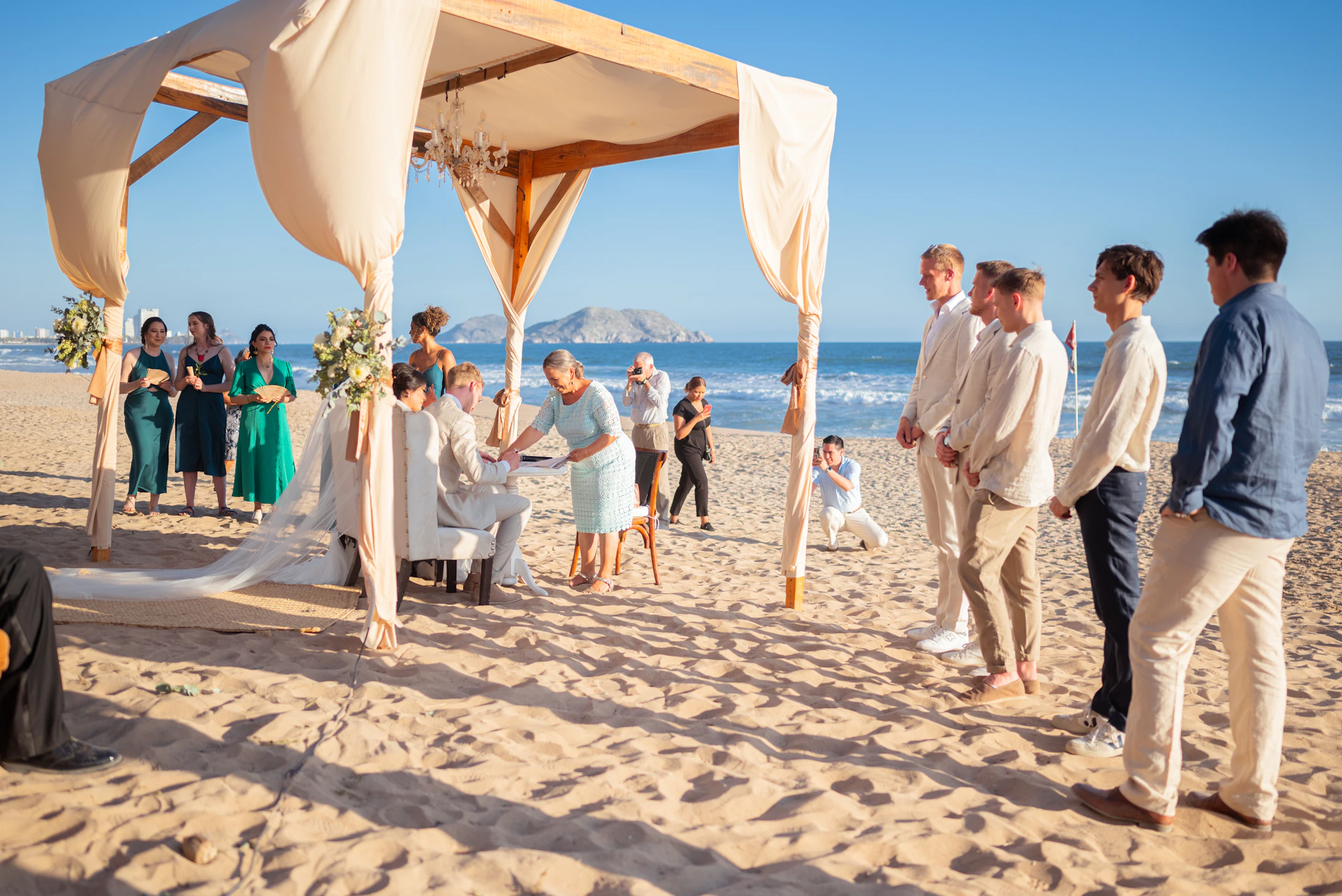 Wedding ceremony taking place on a sunny beach.