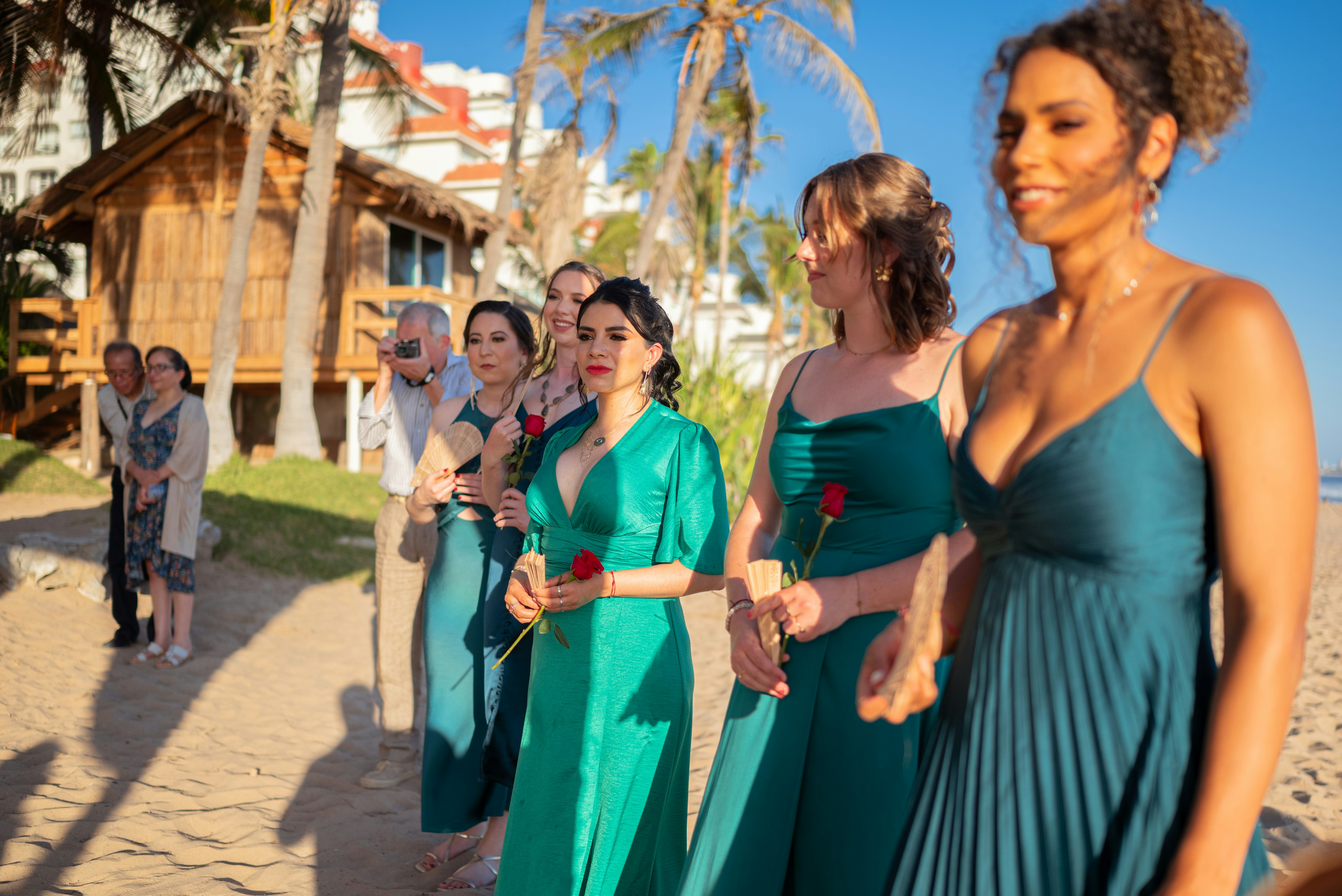 Wedding party standing on a beach with roses